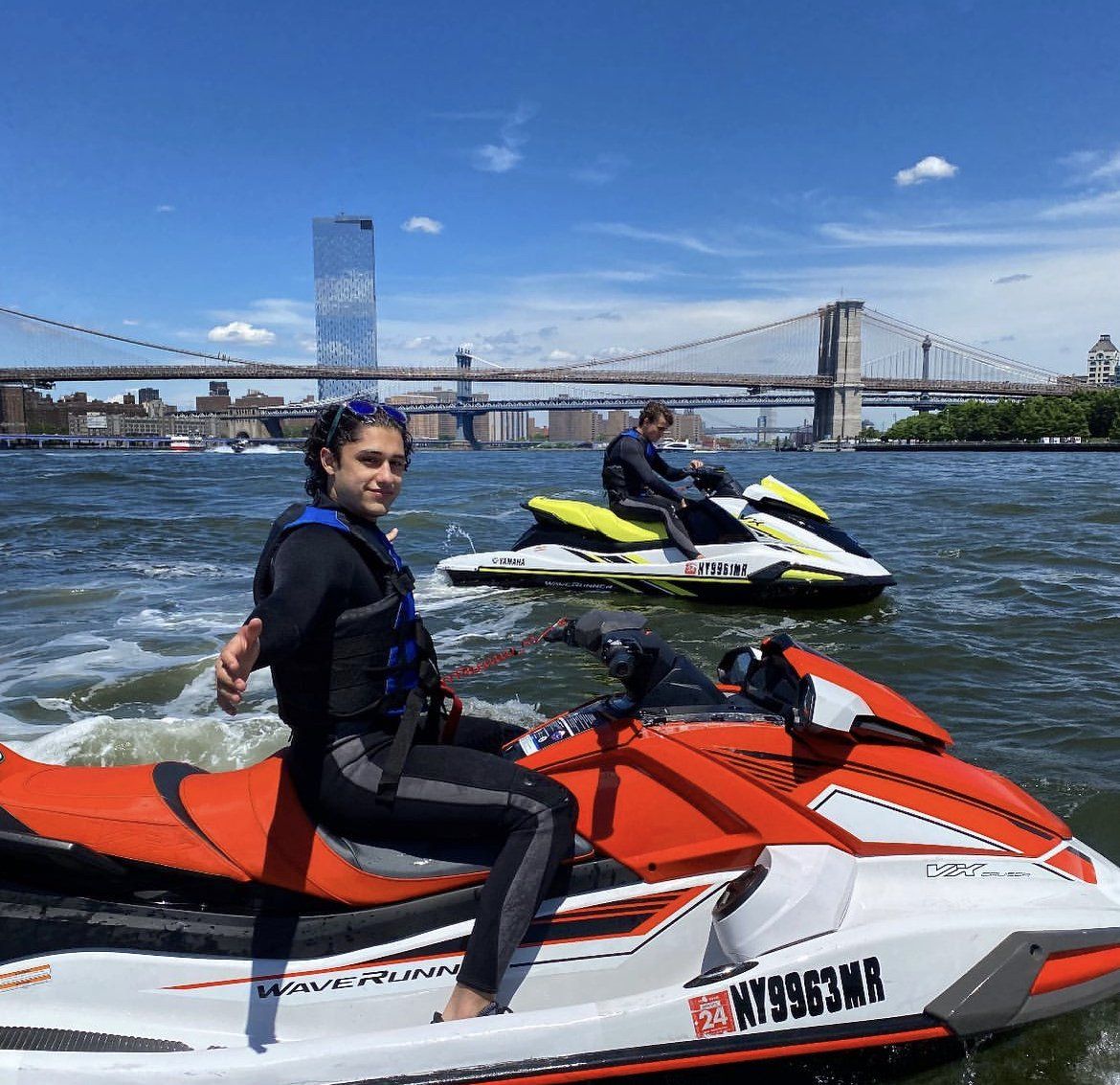 people riding red and yellow jet ski in new york