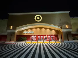 Night exterior of a Target store with a lit entrance and “order pickup” sign over the doors.