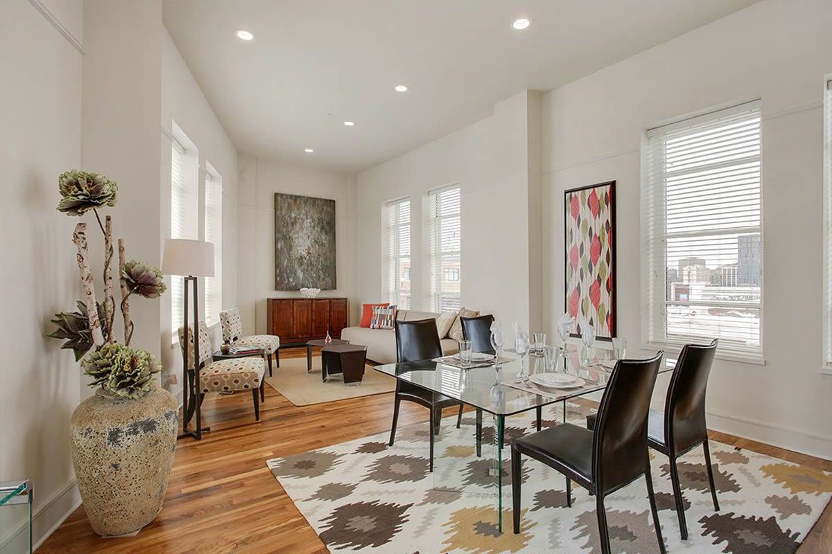 A living room with a table and chairs and a rug