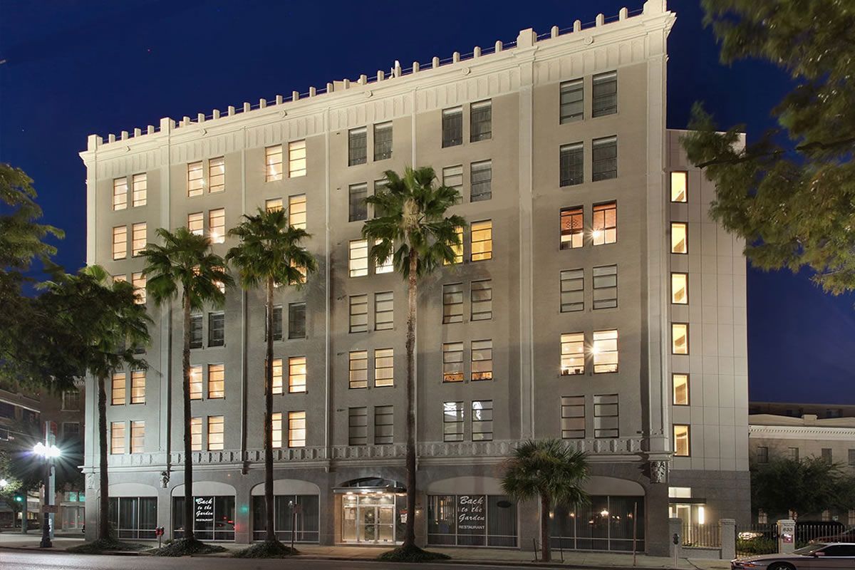 A large building with palm trees in front of it at night