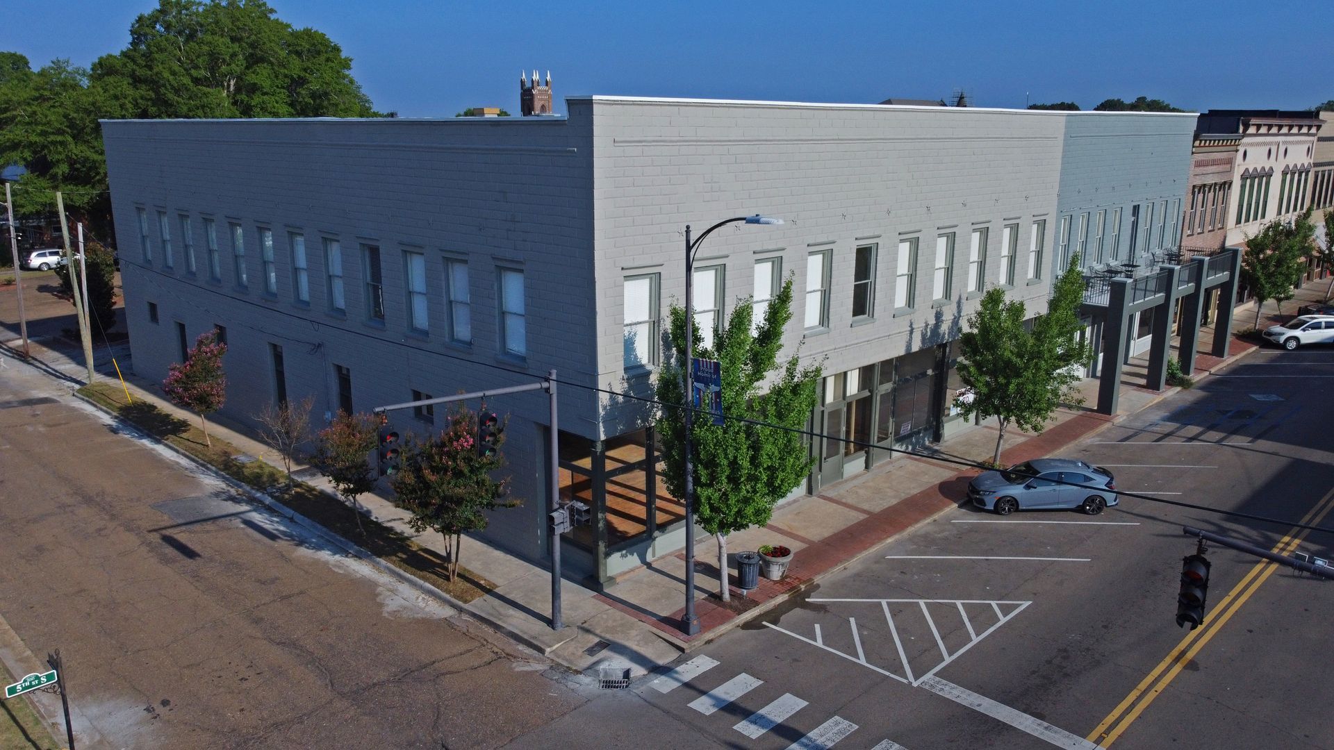 An aerial view of a building on the corner of a city street.