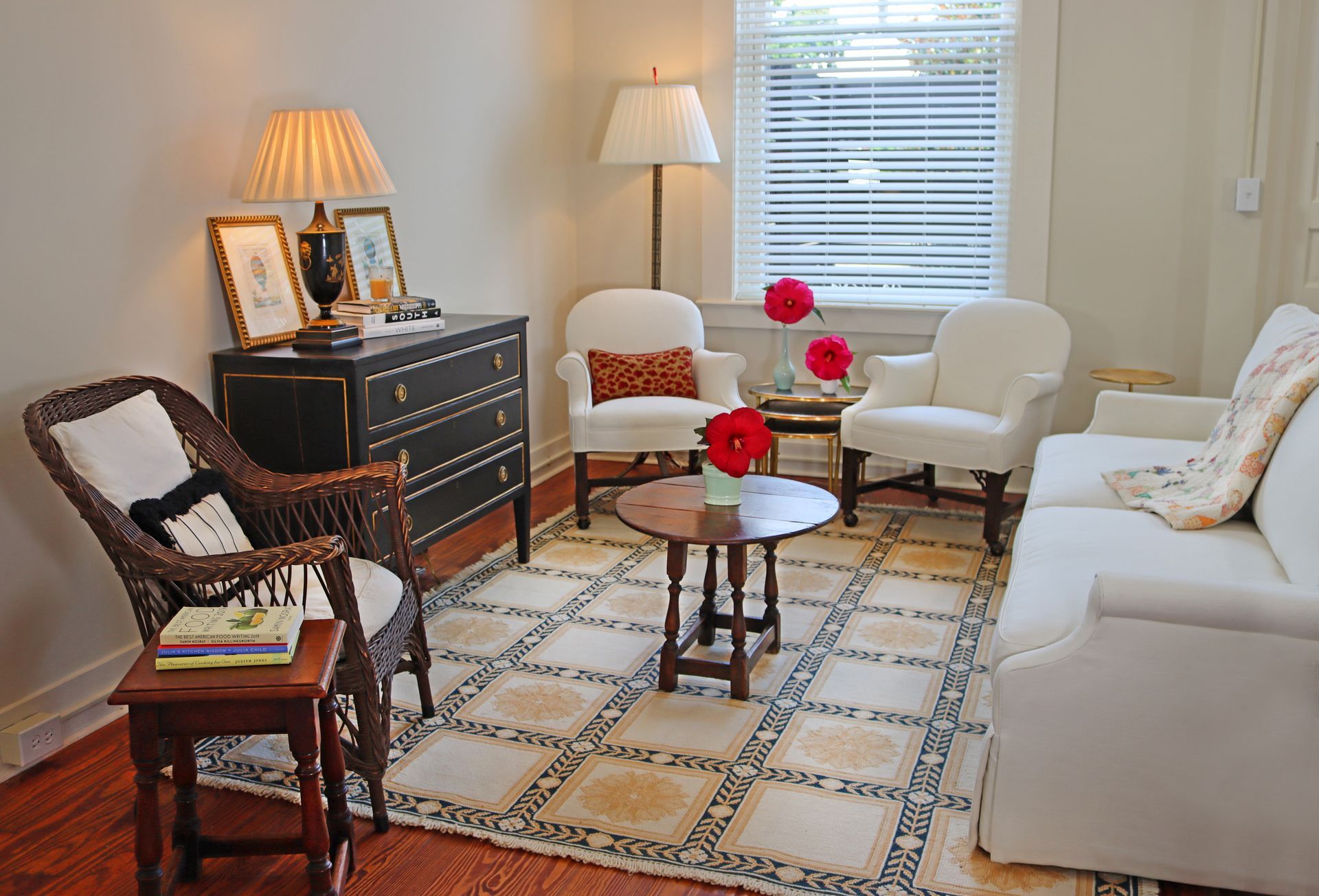 A living room with a white couch and chairs