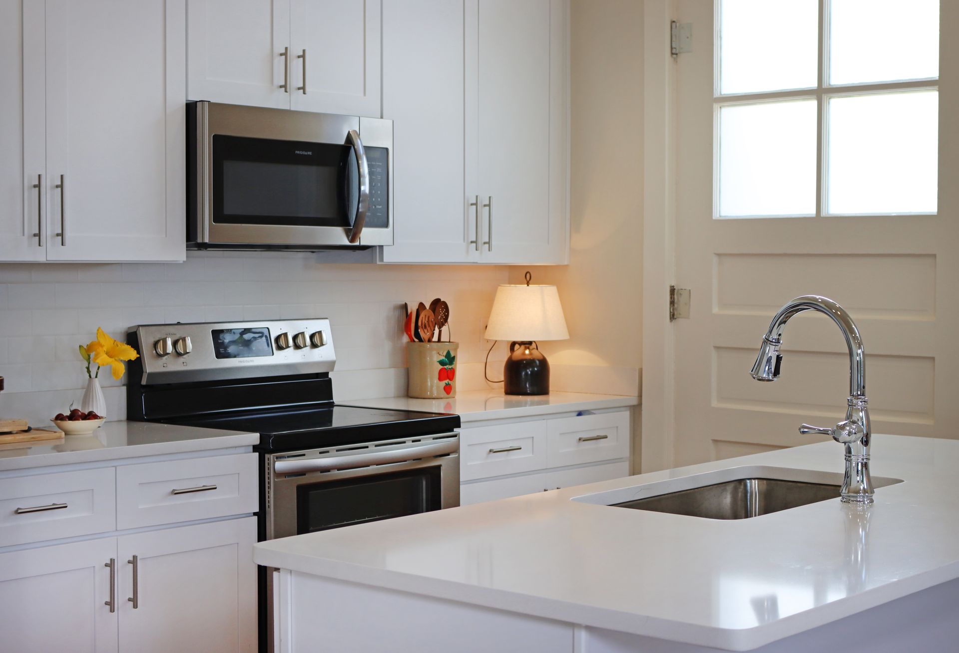 A kitchen with white cabinets and stainless steel appliances