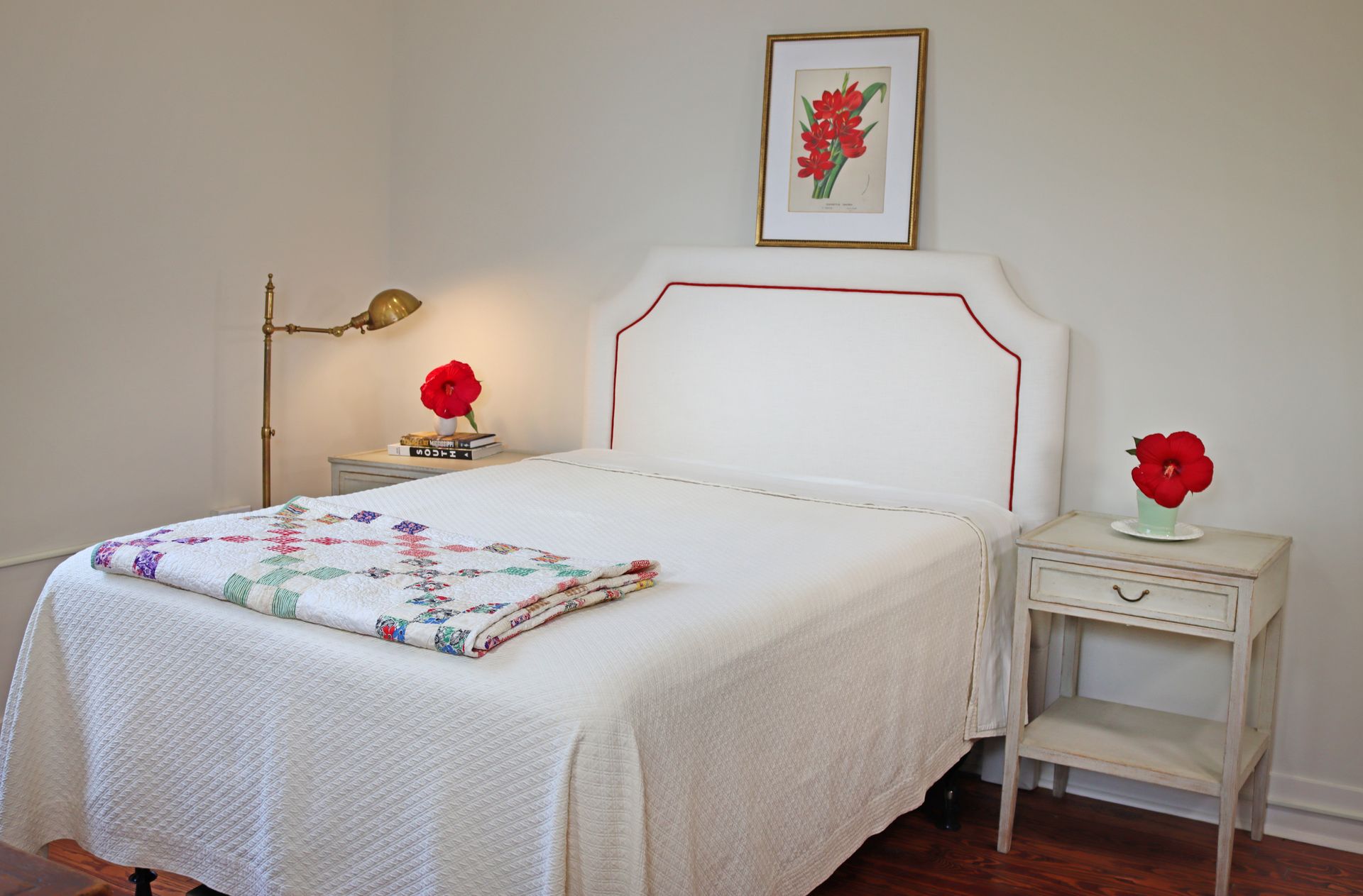 A bedroom with a bed a nightstand and a lamp