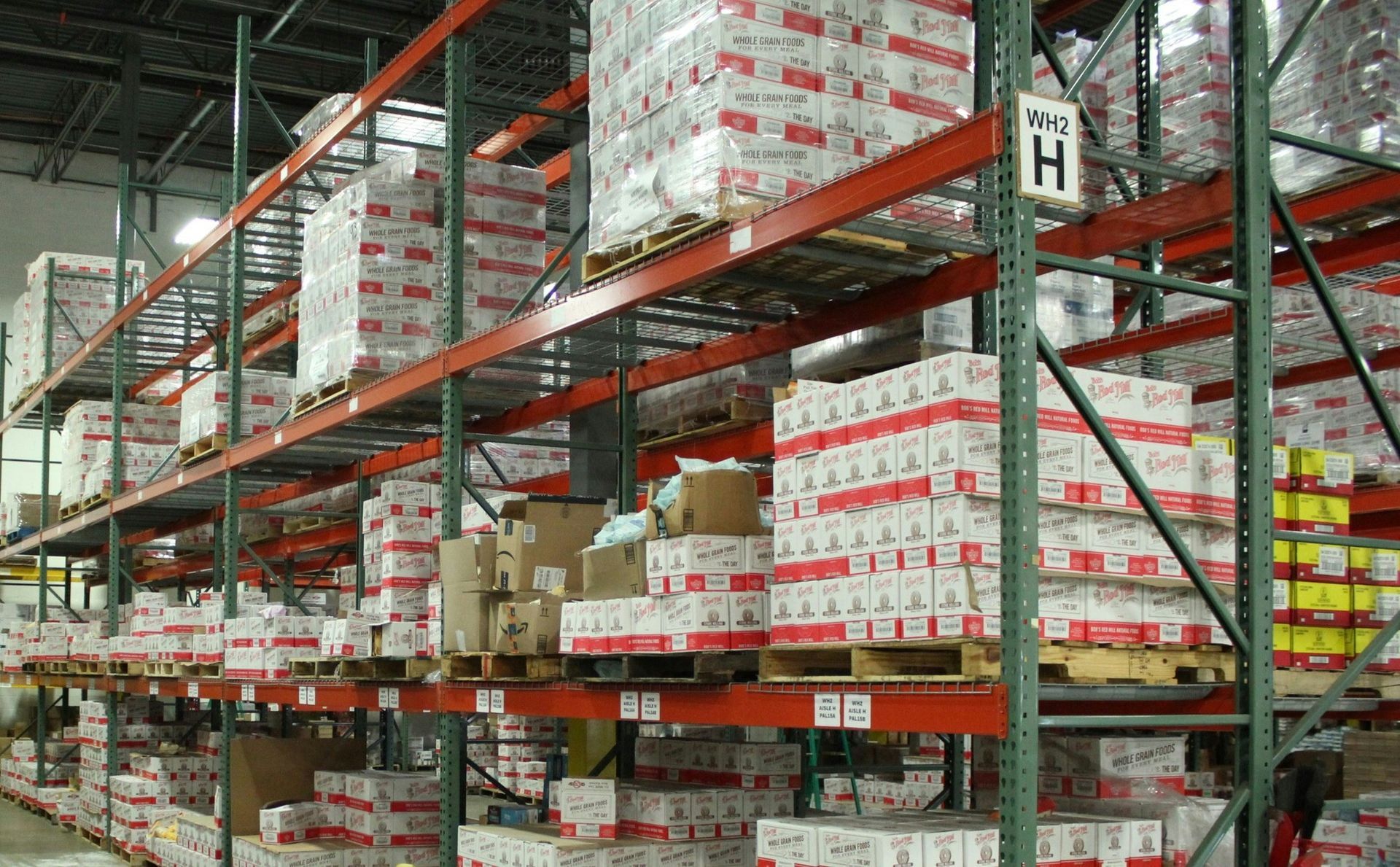 A warehouse filled with lots of boxes and shelves with a sign that says h