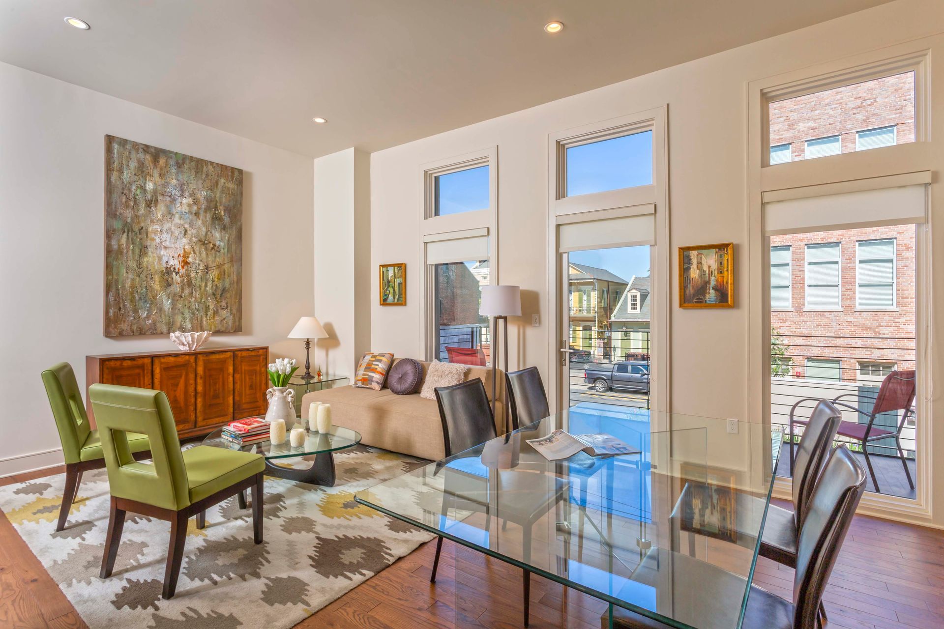 A living room with a glass table and chairs and a couch.