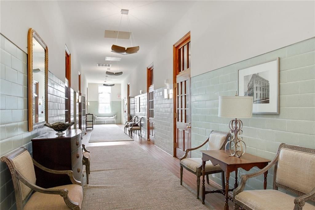 A long hallway with chairs and a table in a building