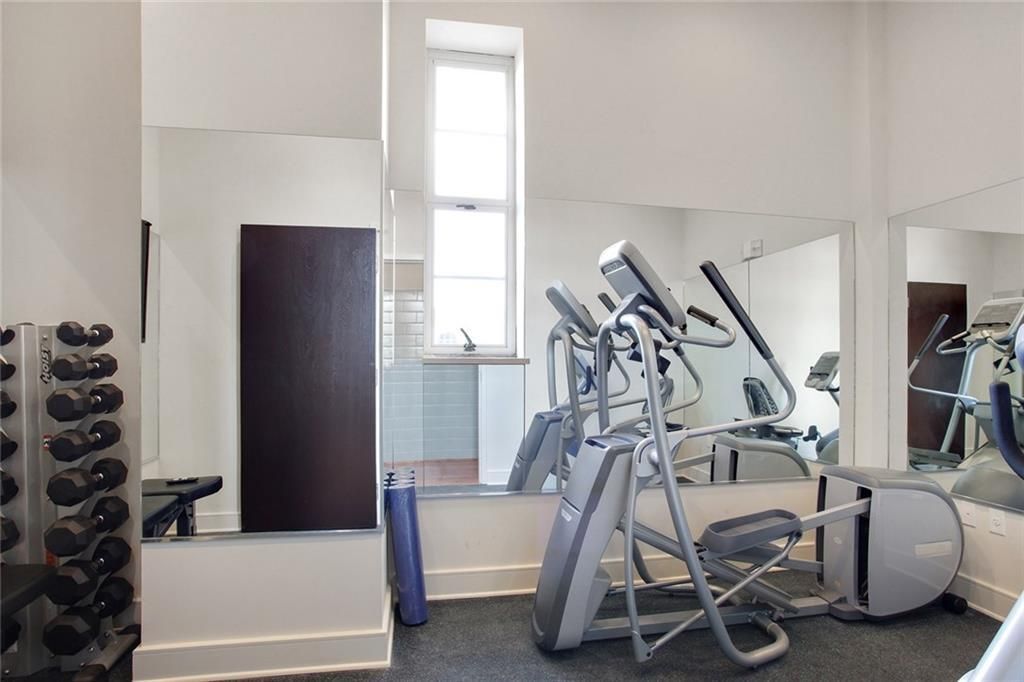 A gym with a lot of mirrors and exercise equipment