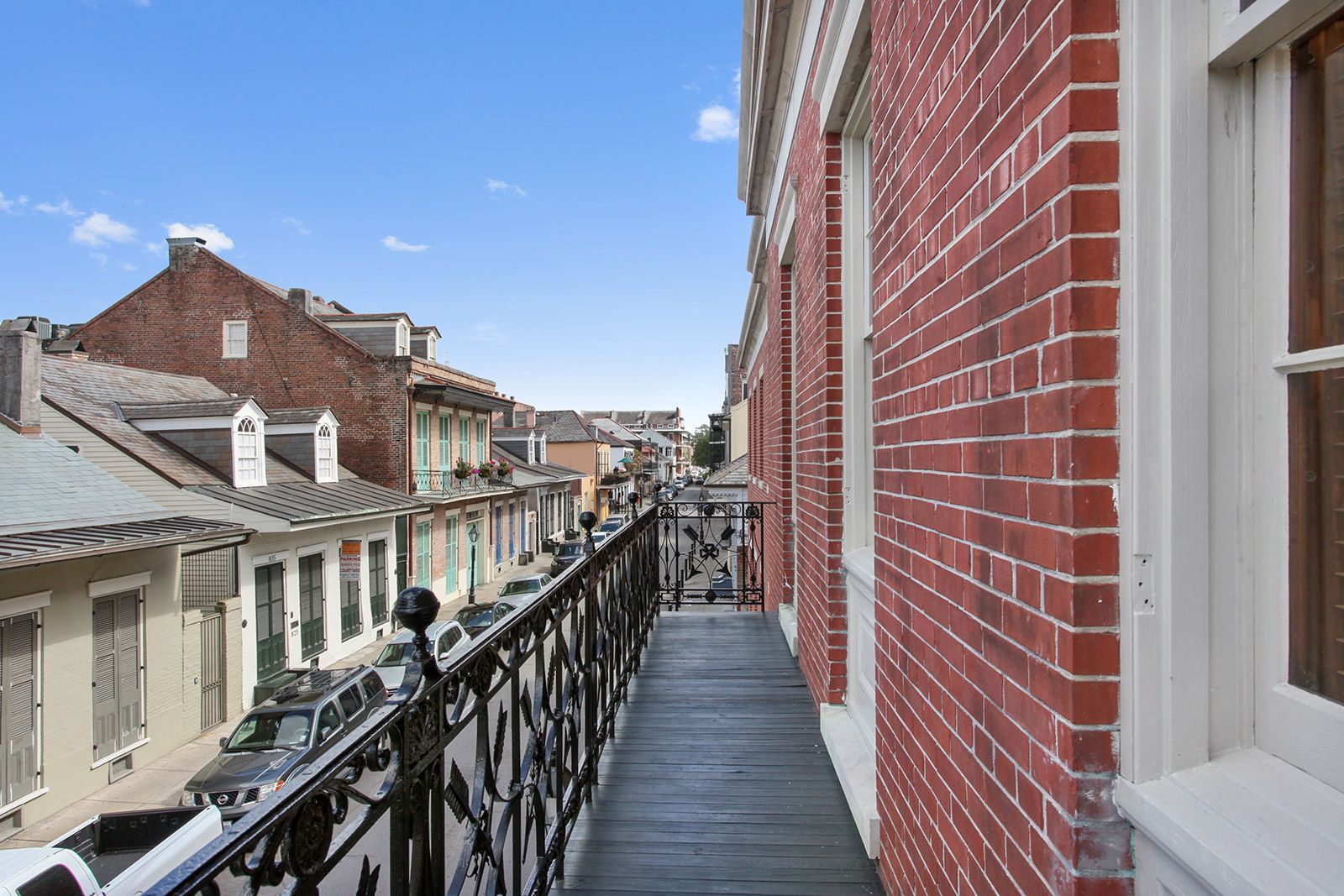 A balcony with a view of a city from a brick building.