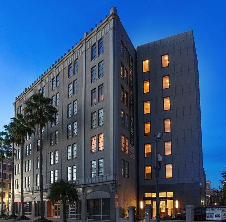 A tall building with many windows and palm trees in front of it