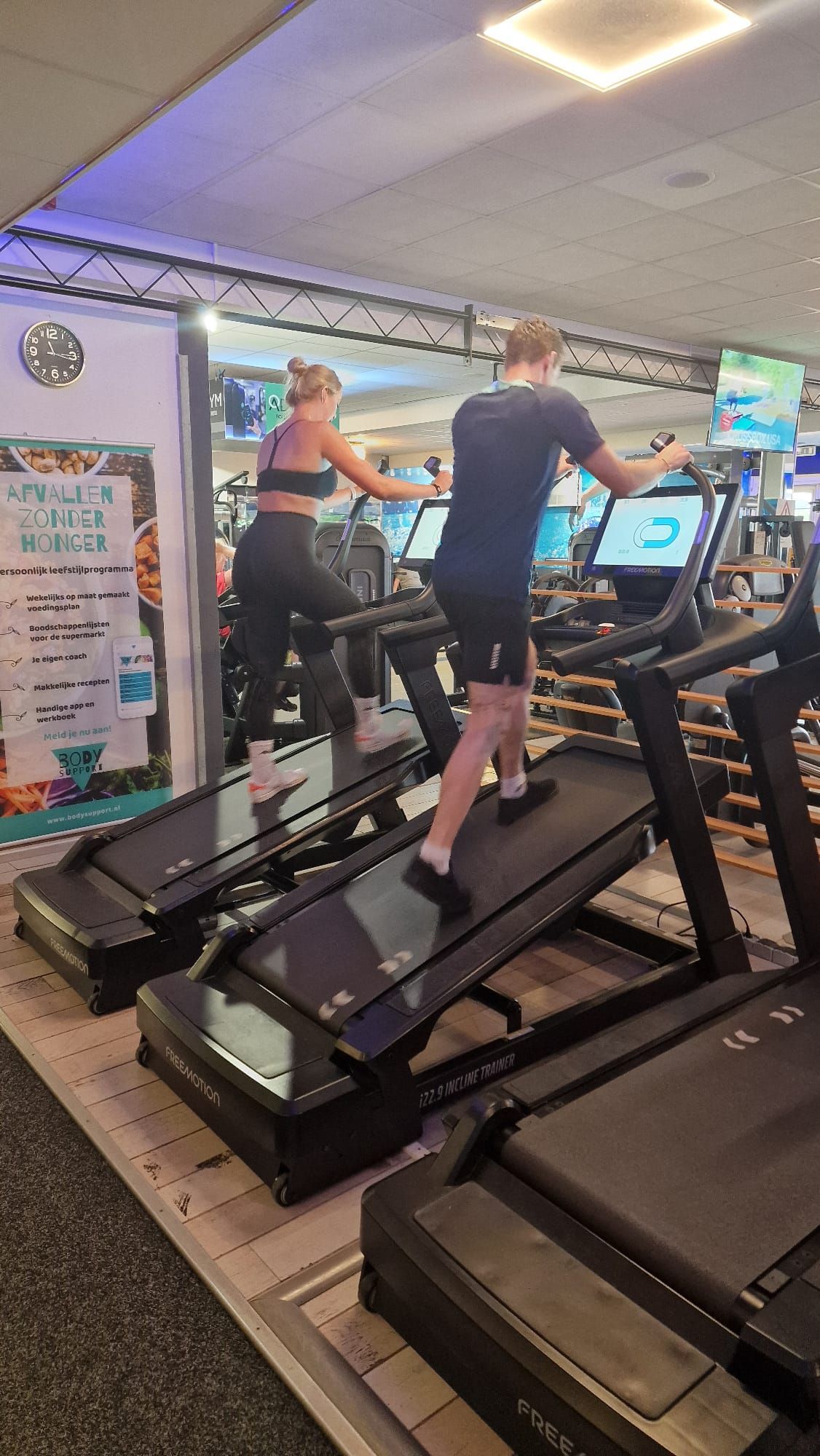 Een vrouw loopt op een loopband in een sportschool.