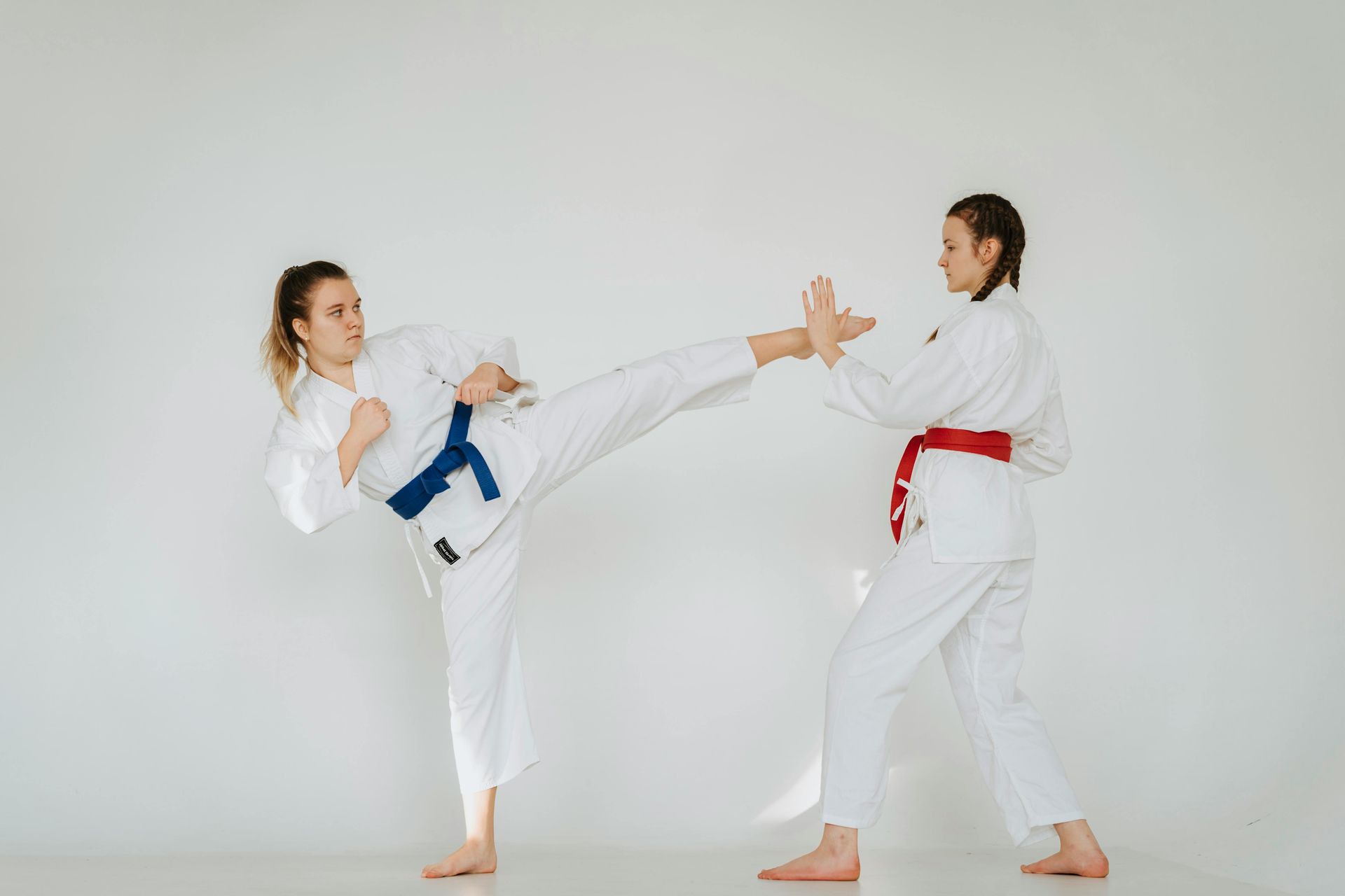 Twee vrouwen beoefenen samen taekwondo in een sportschool.