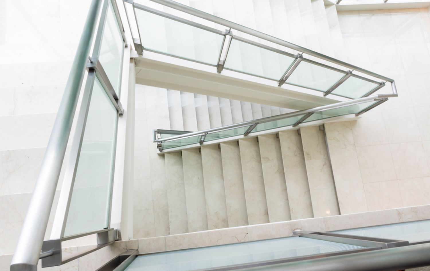 A Set of Stairs With a Glass Railing in a Building — Top Shelf Glass Pool Fencing & Balustrading in Helensvale, QLD