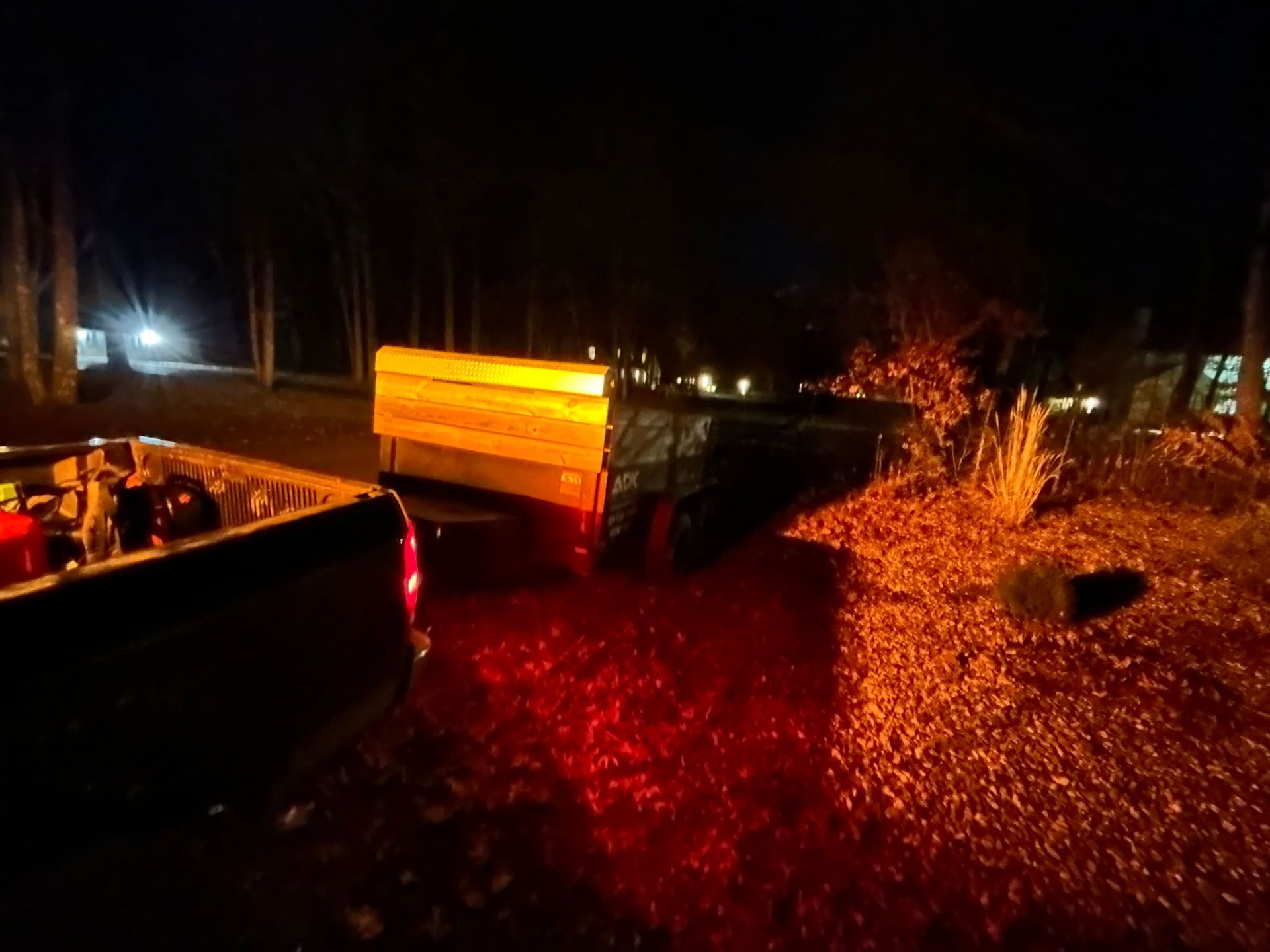 Night crash scene with overturned vehicle, glowing taillights, and debris scattered on a dark road