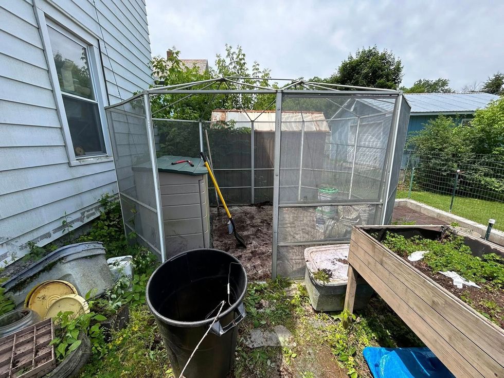 Air conditioning units with toolbox and gloves in backyard.