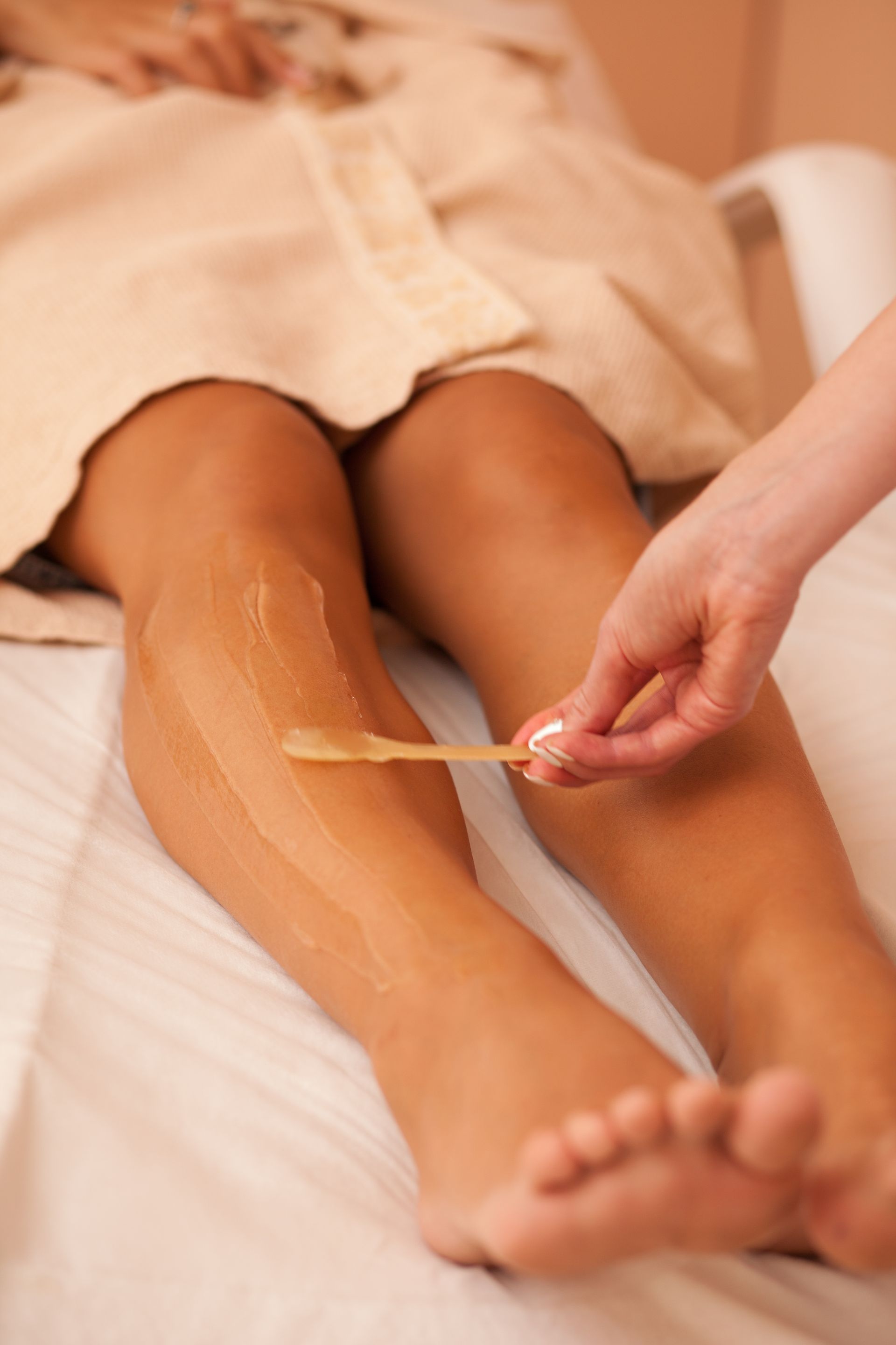 Una donna si sta facendo depilare le gambe in una spa.