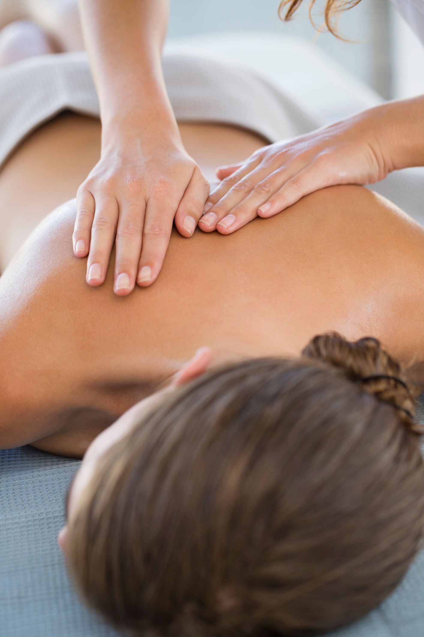 Una donna si sta facendo fare un massaggio alla schiena in una spa.