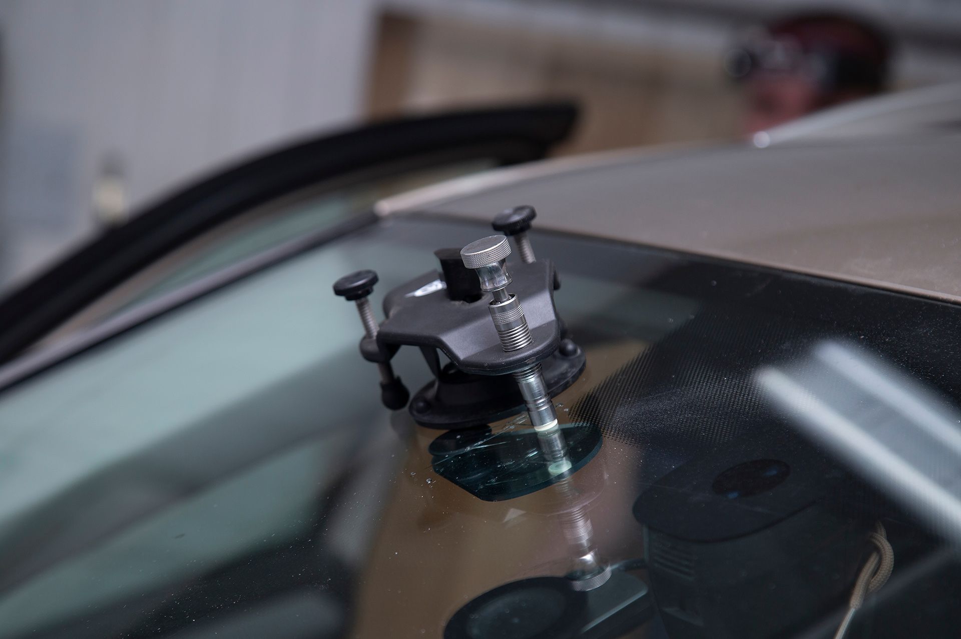 Windshield repair tool attached to a car windshield near a crack