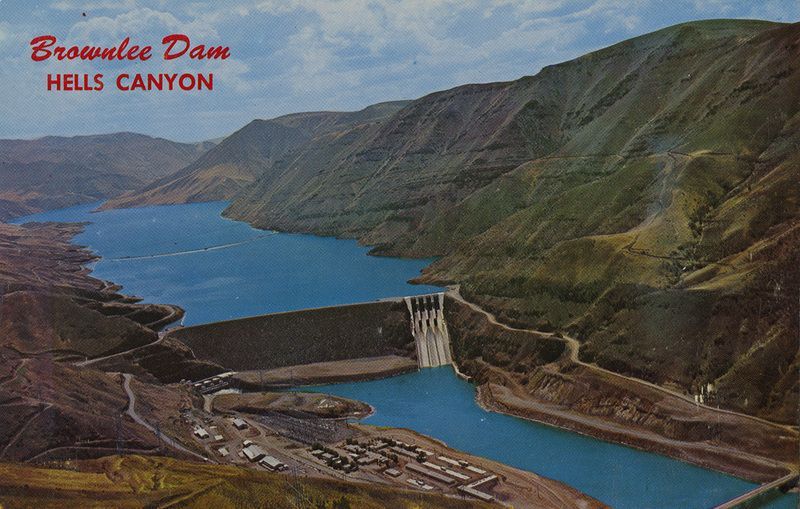 Brownslee Dam in Hells Canyon spanning a blue river between steep brown-green mountains