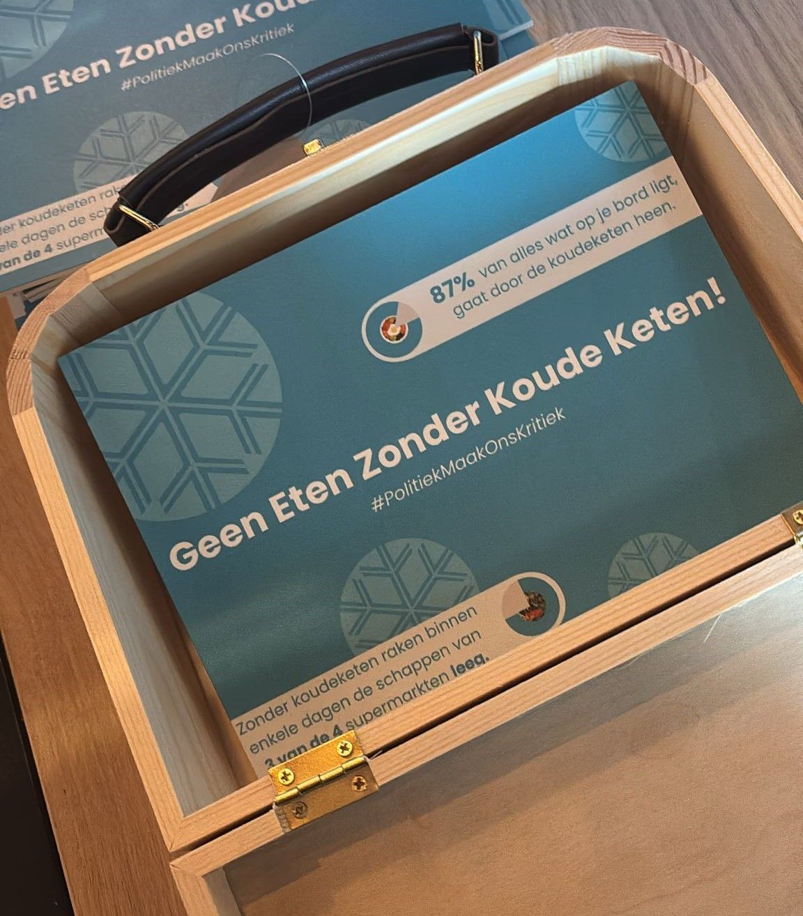 foto van een open koffertje met een bordje met de tekst geen eten zonder koude keten!
