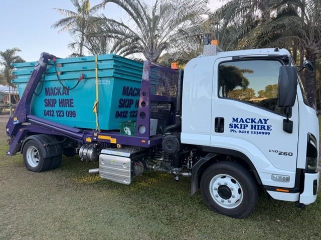 A Blue Waste Container on a Truck, Parked on a Paved Road Under a Bright Blue Sky — Mackay Skip Hire In Andergrove, QLD