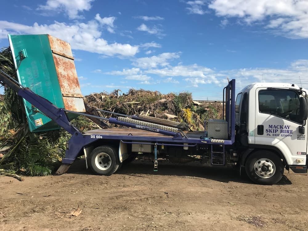 Skip Bin Truck Lifting a Green and Rusty Container Filled — Mackay Skip Hire In Andergrove, QLD