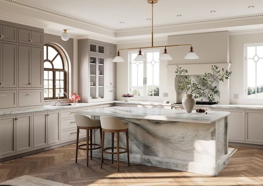 Elegant kitchen with marble island, cabinets, and hardwood floors; beige and gold tones.