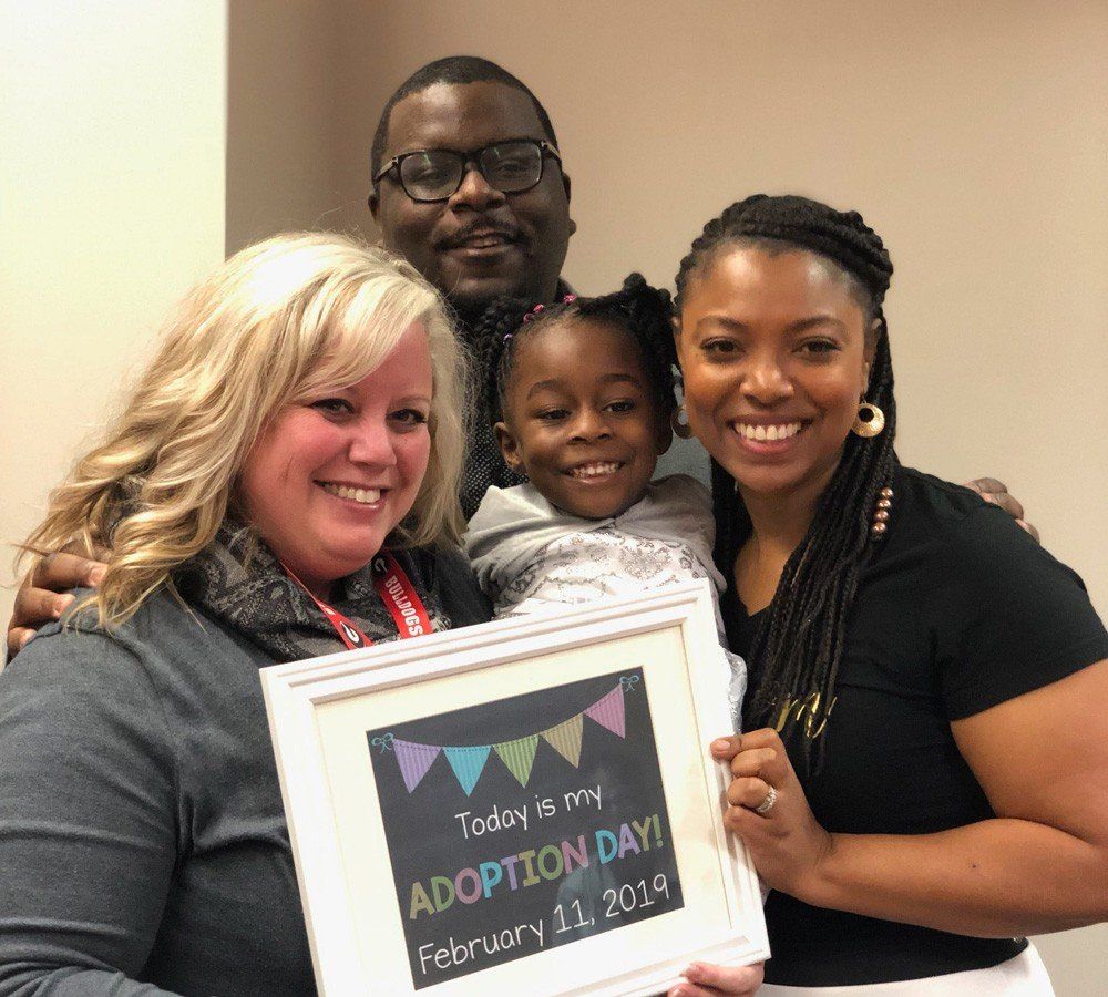 A group of people are holding a sign that says today is my adoption day.