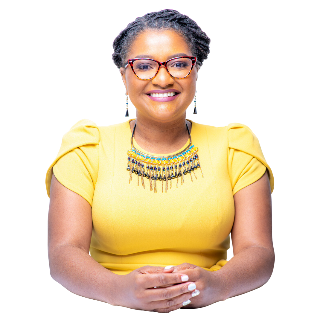 A woman wearing glasses and a yellow shirt is sitting with her hands folded.