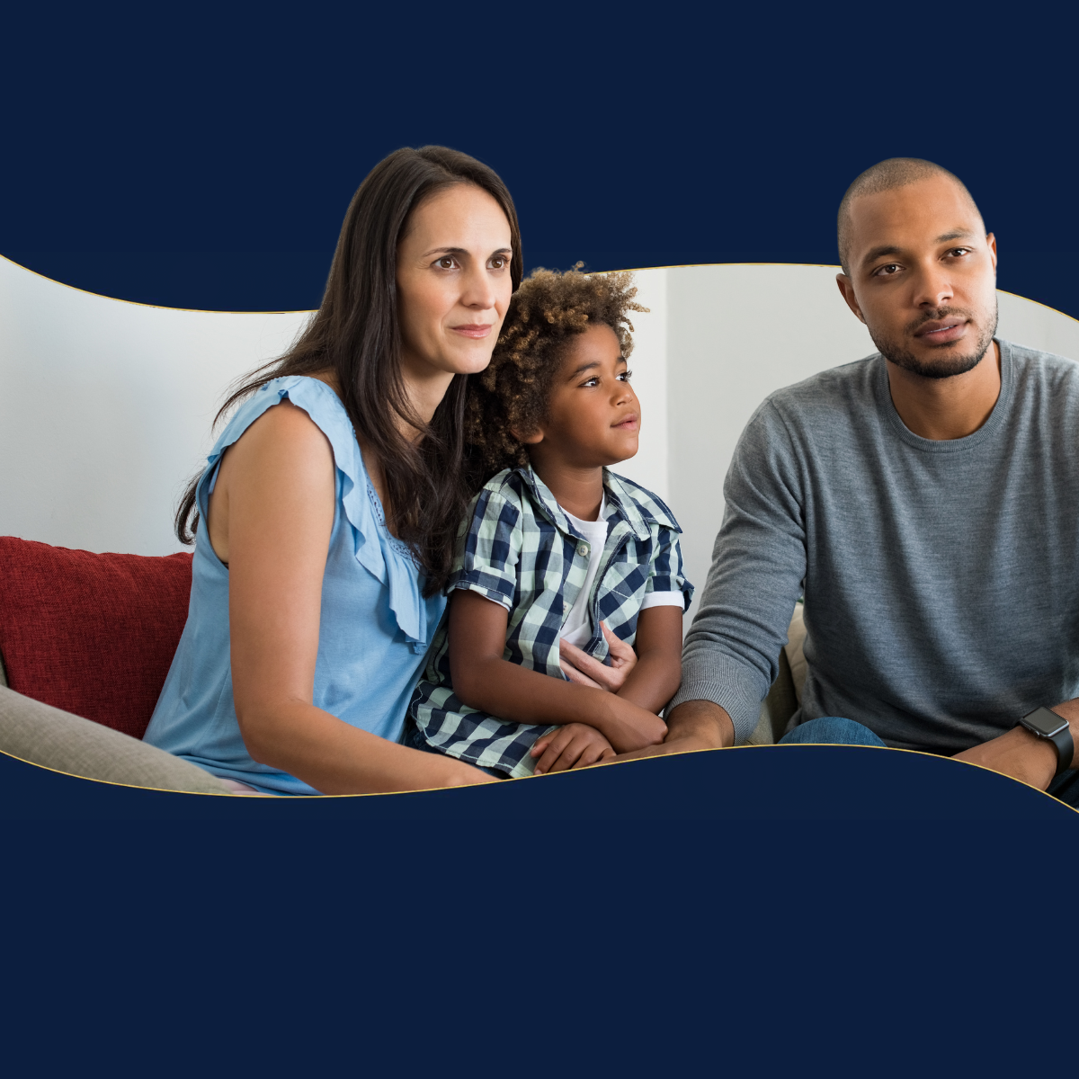 A man and woman are sitting on a couch with a child