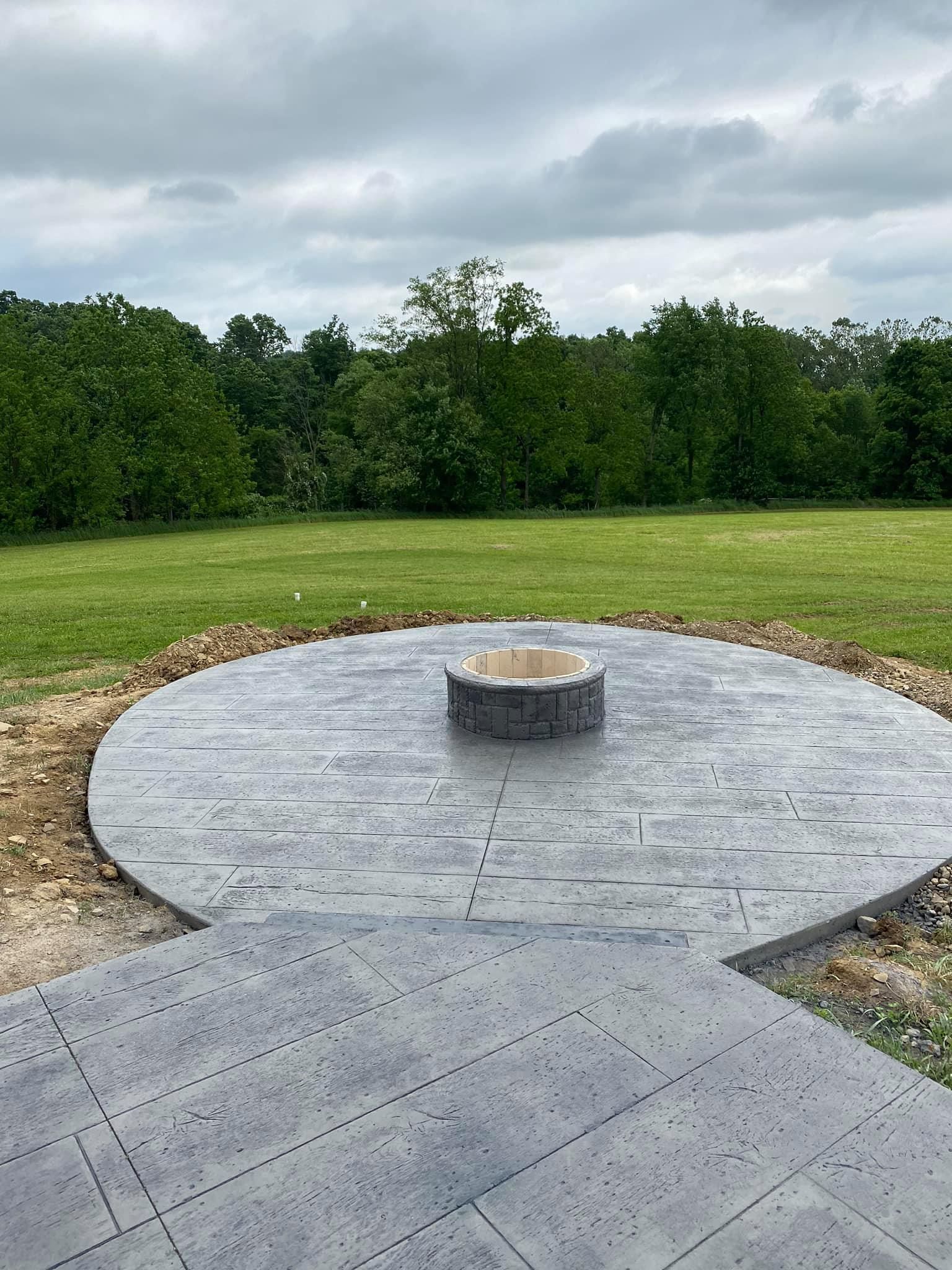 A fire pit is sitting in the middle of a circular patio.