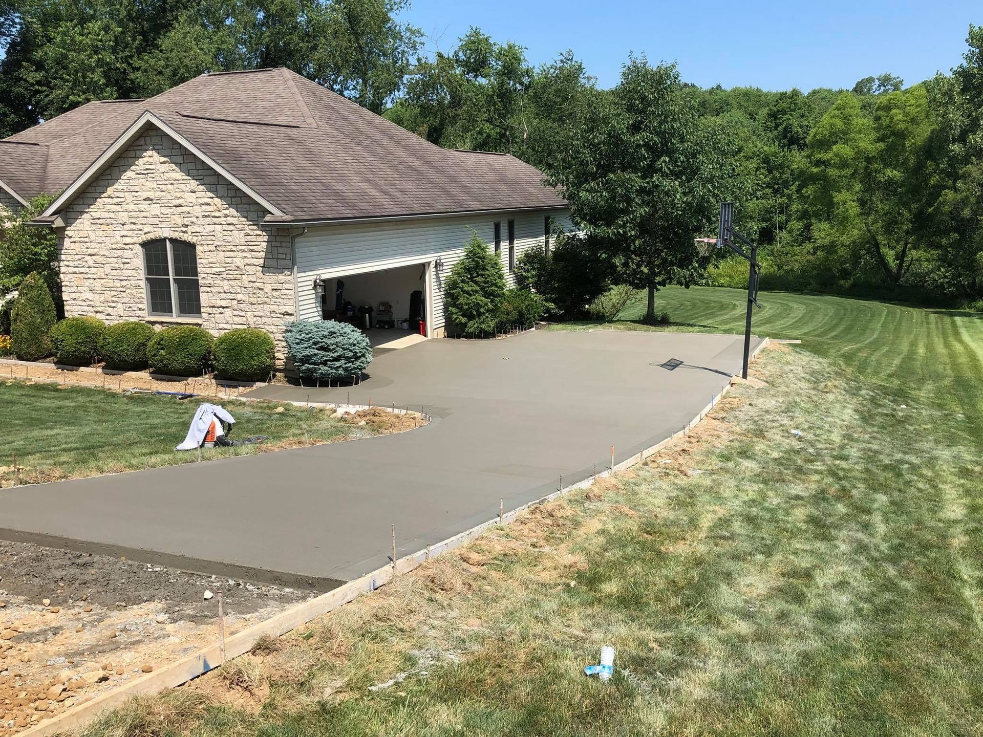 A brick house with a concrete driveway in front of it.