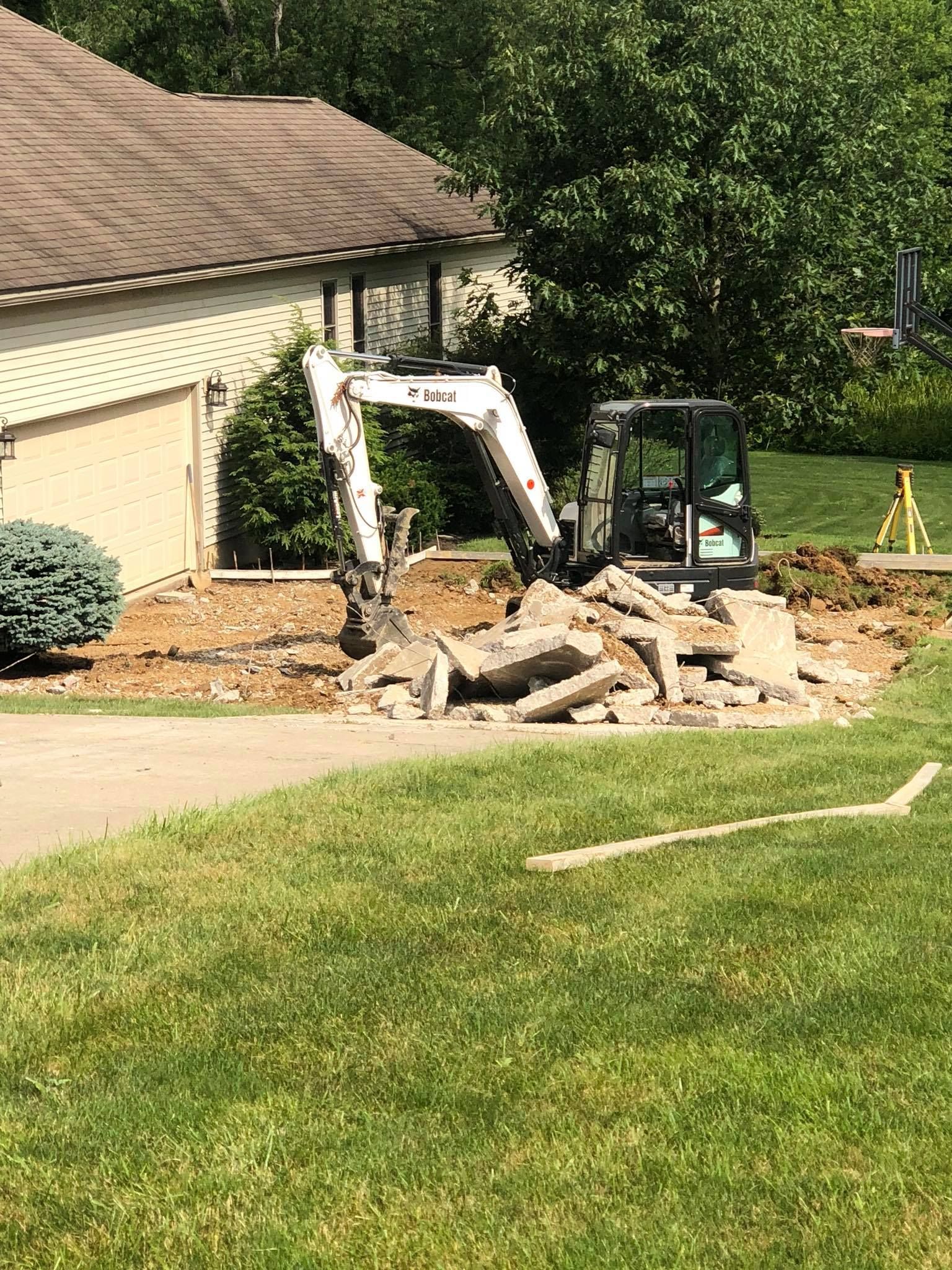 A bulldozer is moving dirt in front of a house.