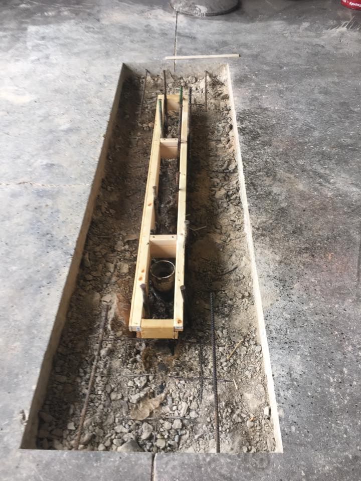 A wooden box is sitting in the middle of a hole in the ground.