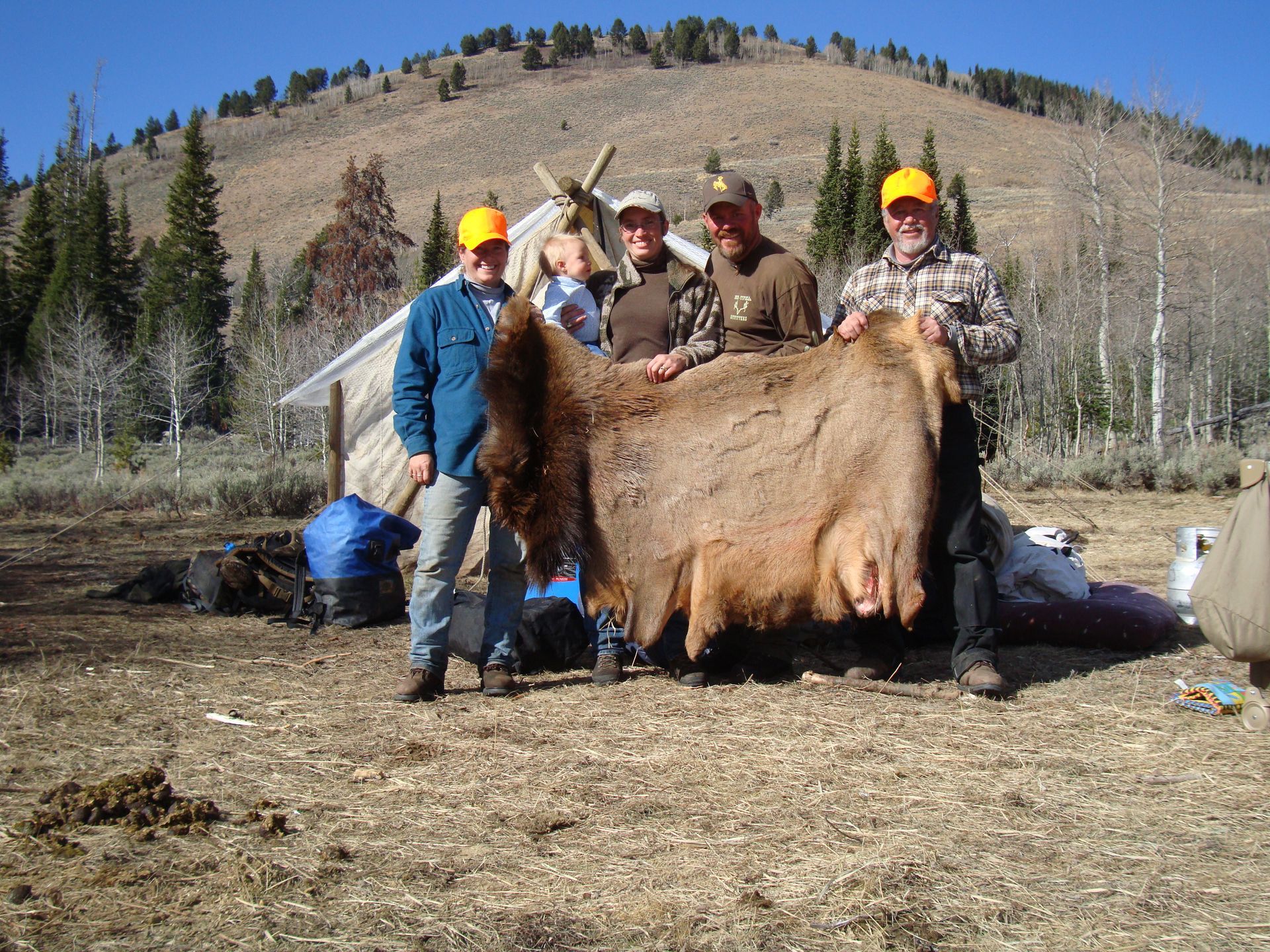 A group of men holding a large piece of fur