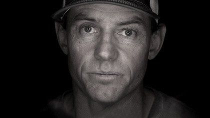 A black and white photo of a man wearing a hat.