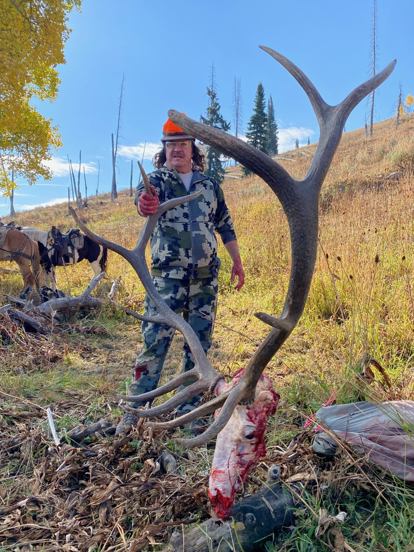 A man standing next to a large deer antlers