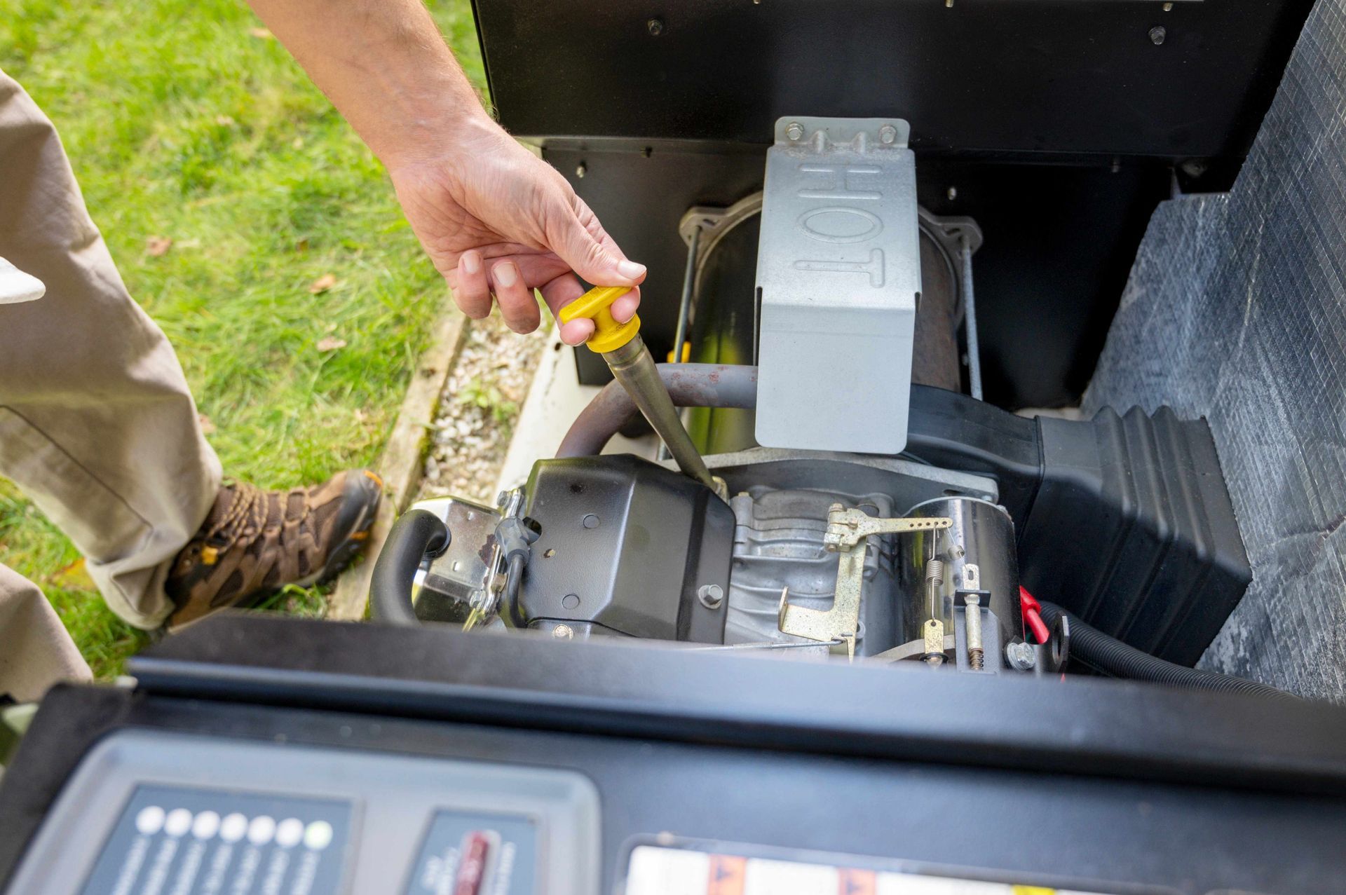 a man is using a screwdriver to fix a generator .