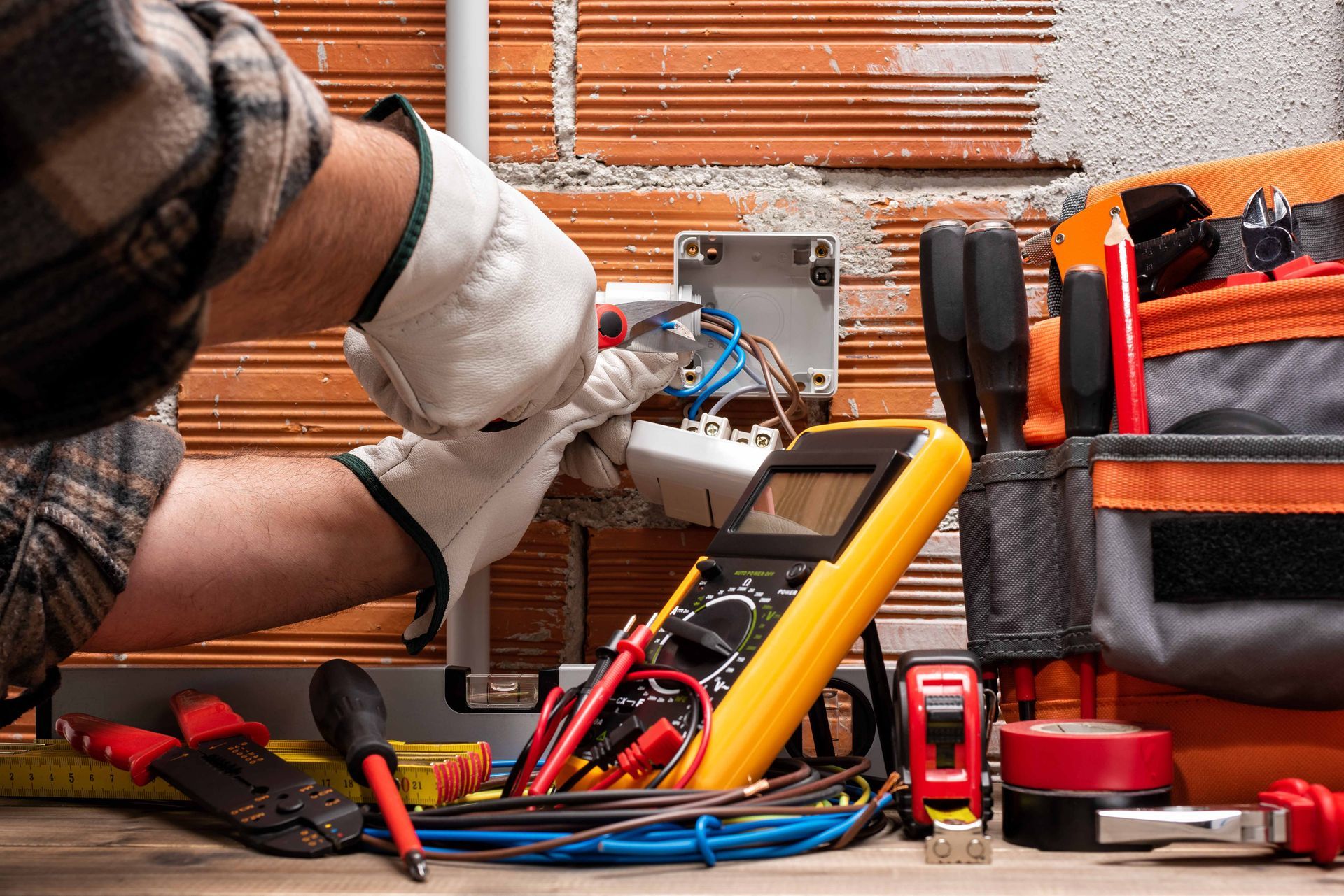 a man is working on an electric box with a multimeter .