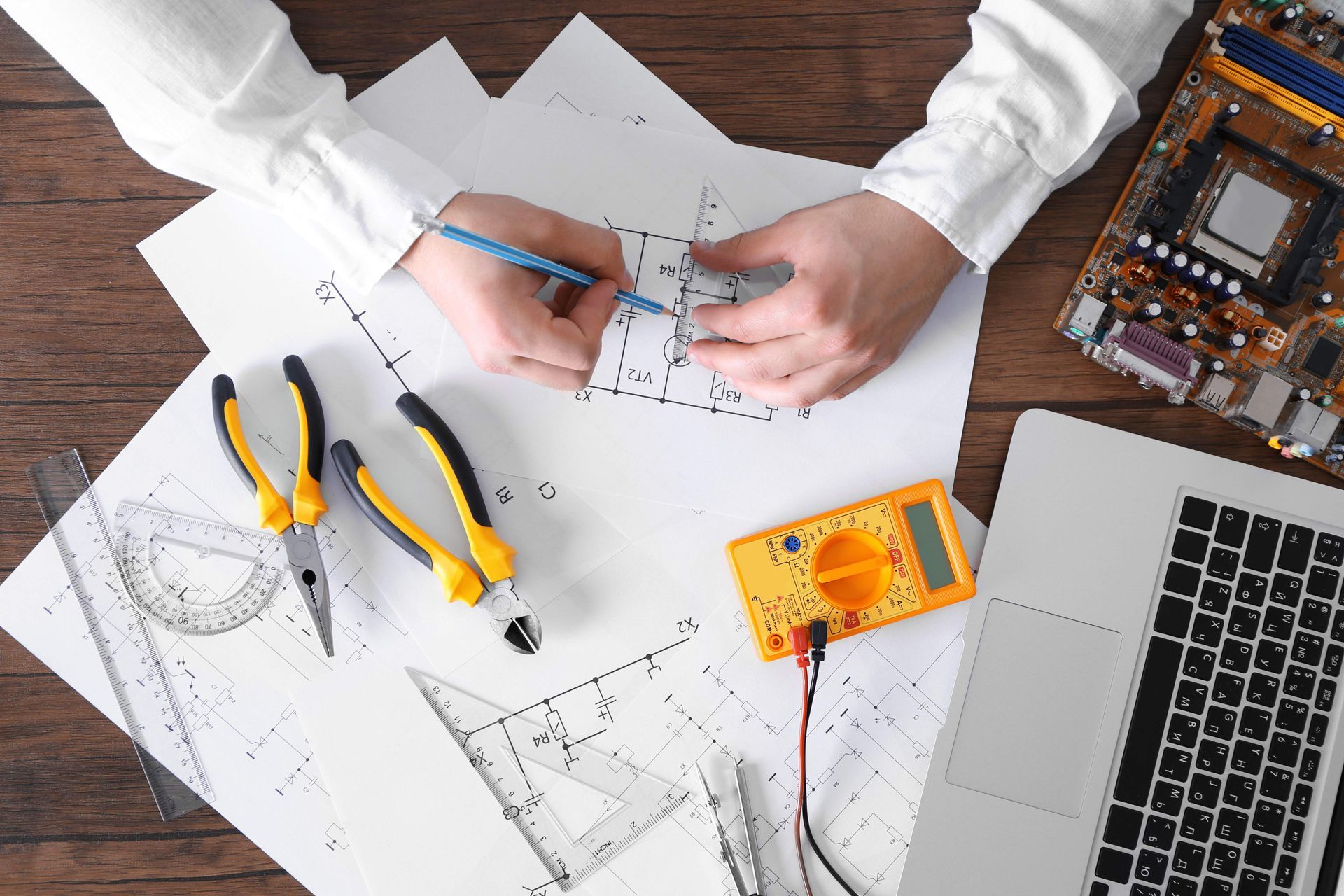 a person is sitting at a table with a laptop and tools .