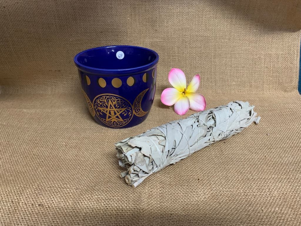 A Blue Bowl and A White Sage Stick Are Sitting on A Table — Crystal Cauldron in South Mackay, QLD