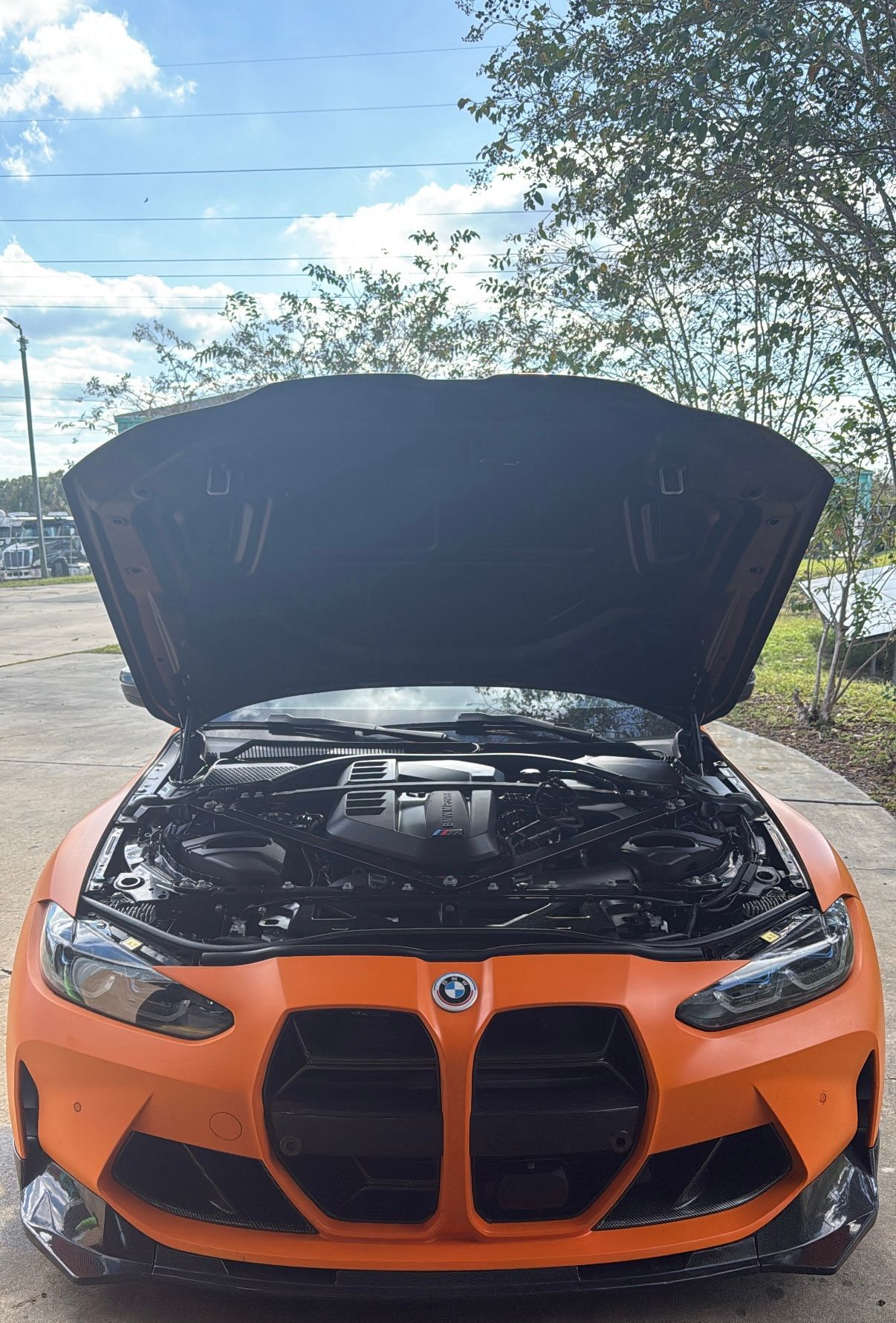 Orange BMW Car with hood up parked outside | Krystal Automotive