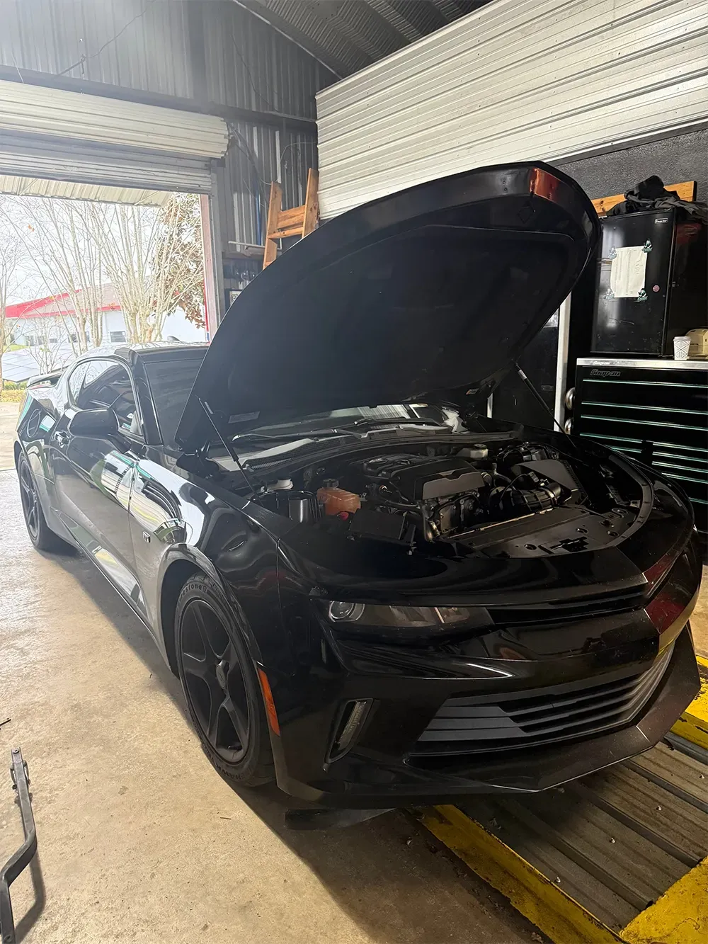 Black Chevrolet car with hood up for auto repair in garage in Ocala, FL | Krystal Automotive