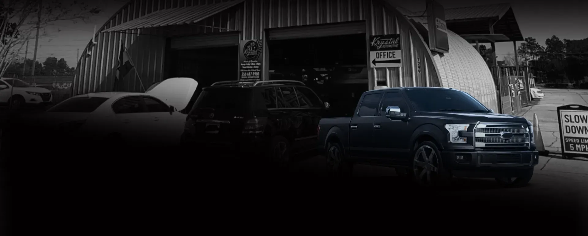 Outside of our shop in Ocala, FL with Black Truck | Krystal Automotive