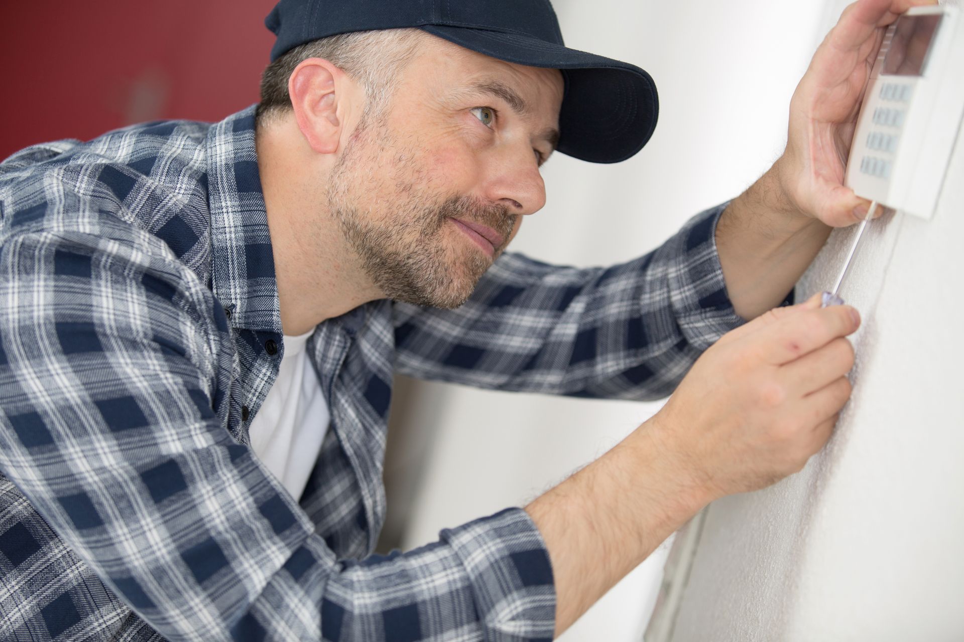 HVAC technician repairing digital heating and cooling thermostat. HVAC technician repairing digital heating and cooling thermostat.