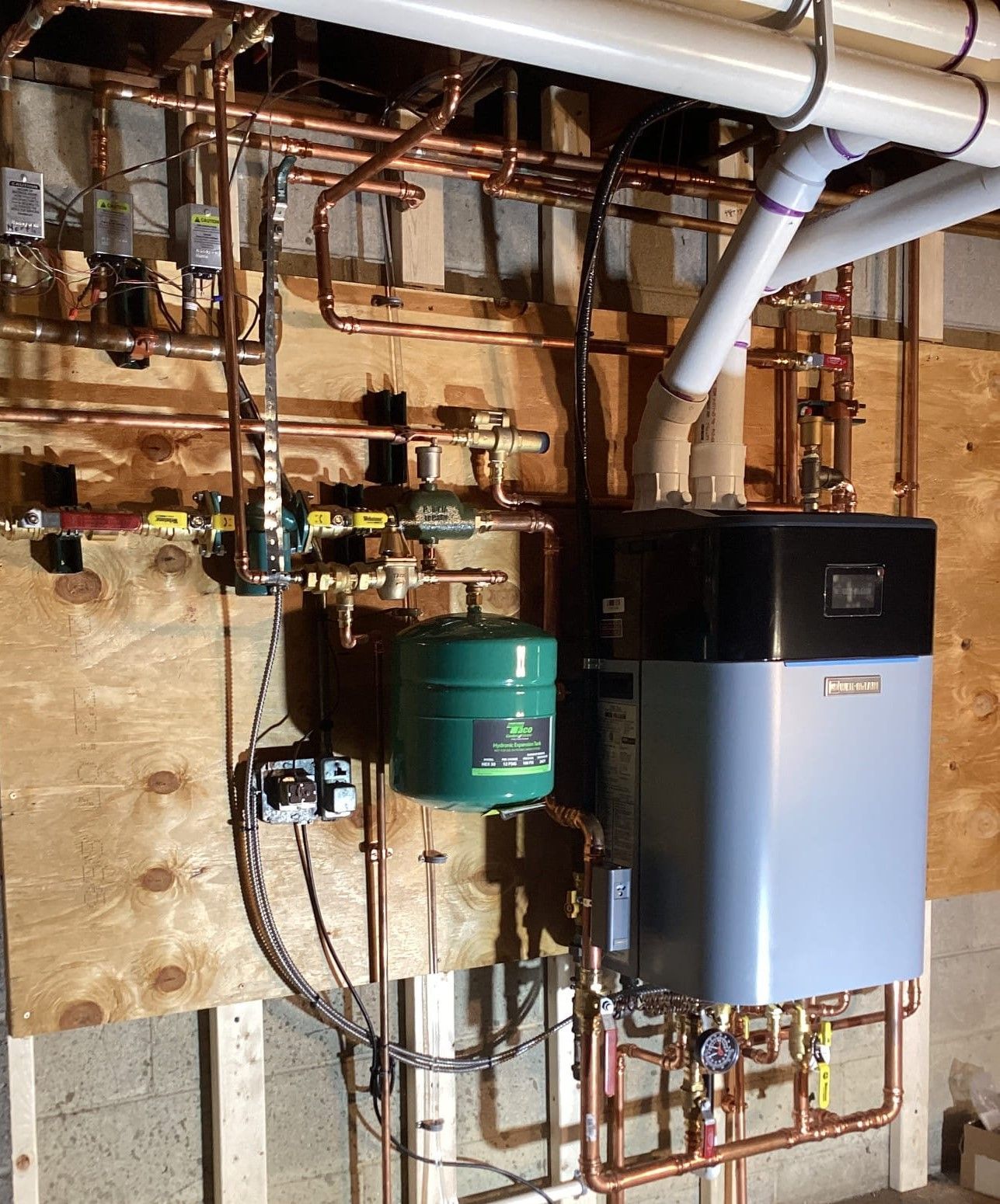 A water heater with a green tank attached to it