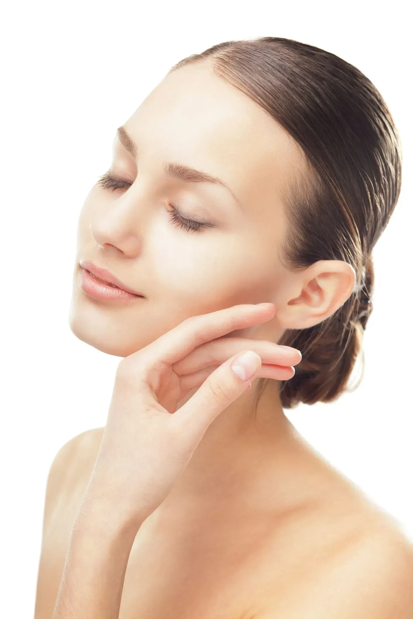 Woman with eyes closed, gently touching her cheek against a white background