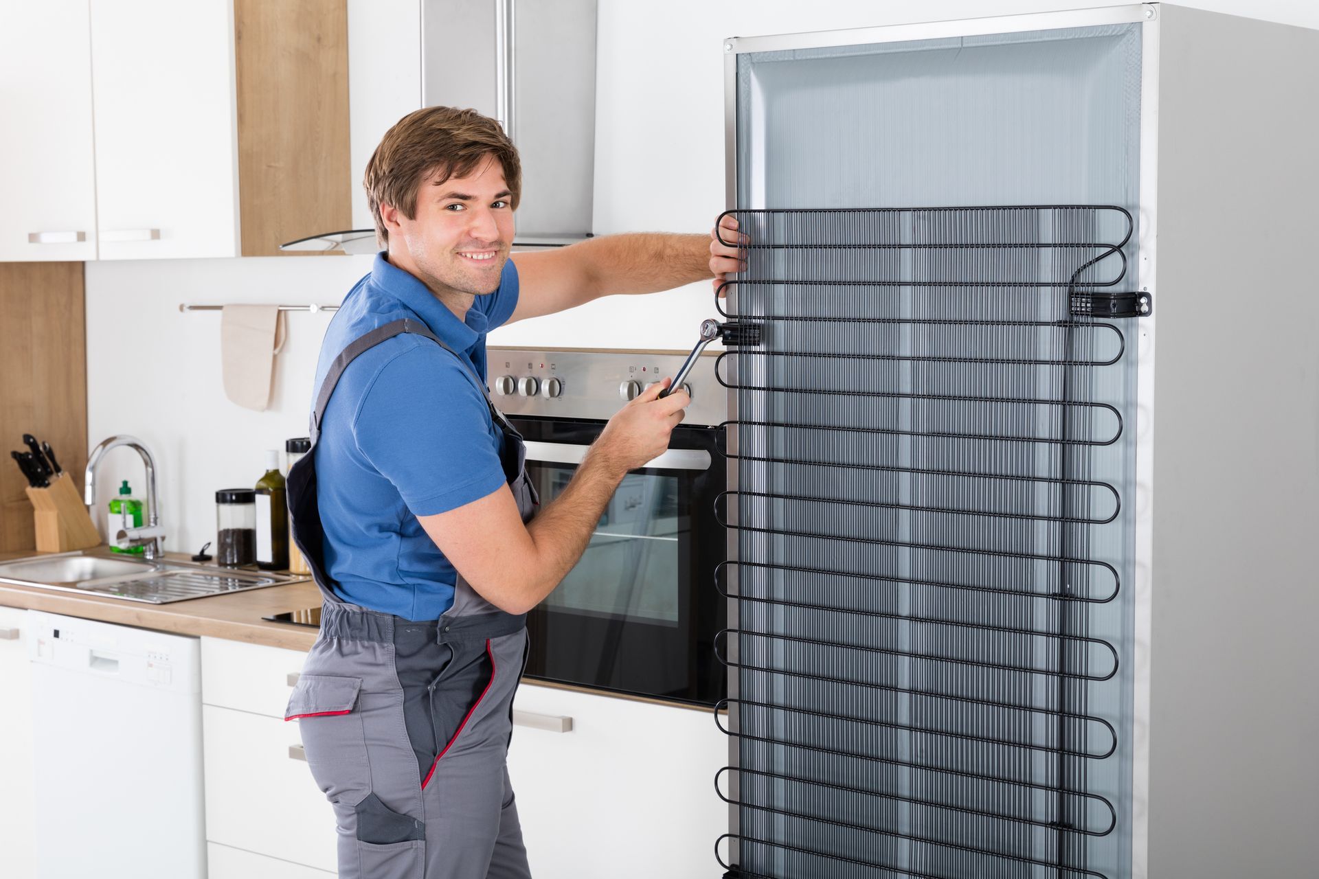 Service technician working on refrigerator with screwdriver