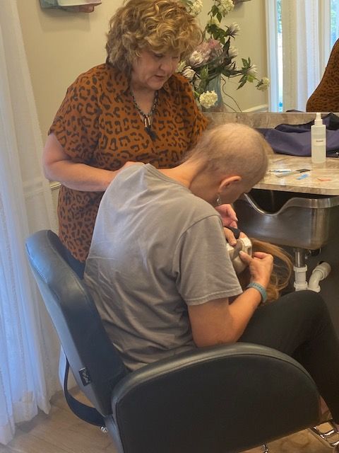 Woman with hair loss has wig fitted by stylist in salon.