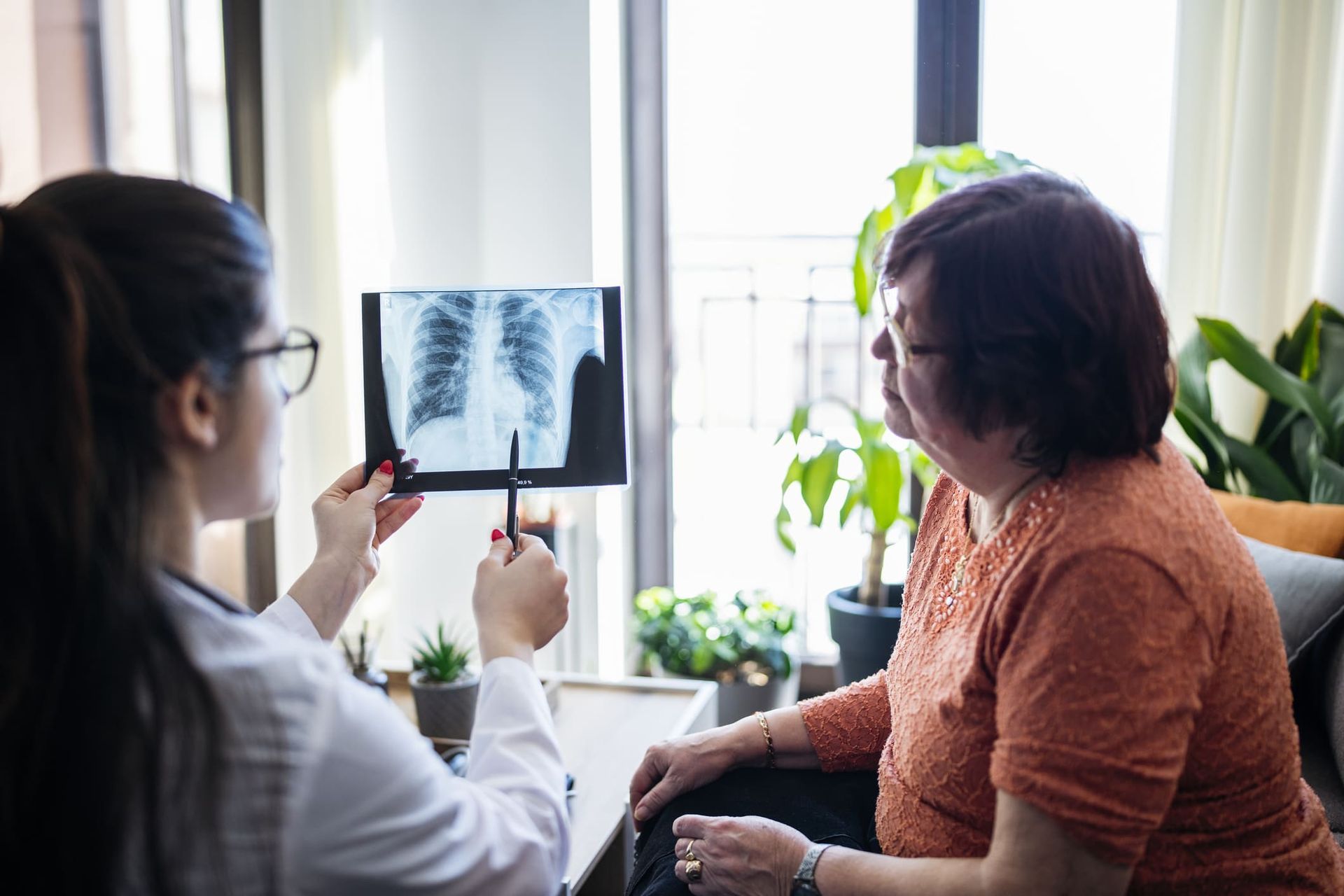 A doctor is looking at an x-ray of a patient 's lungs.